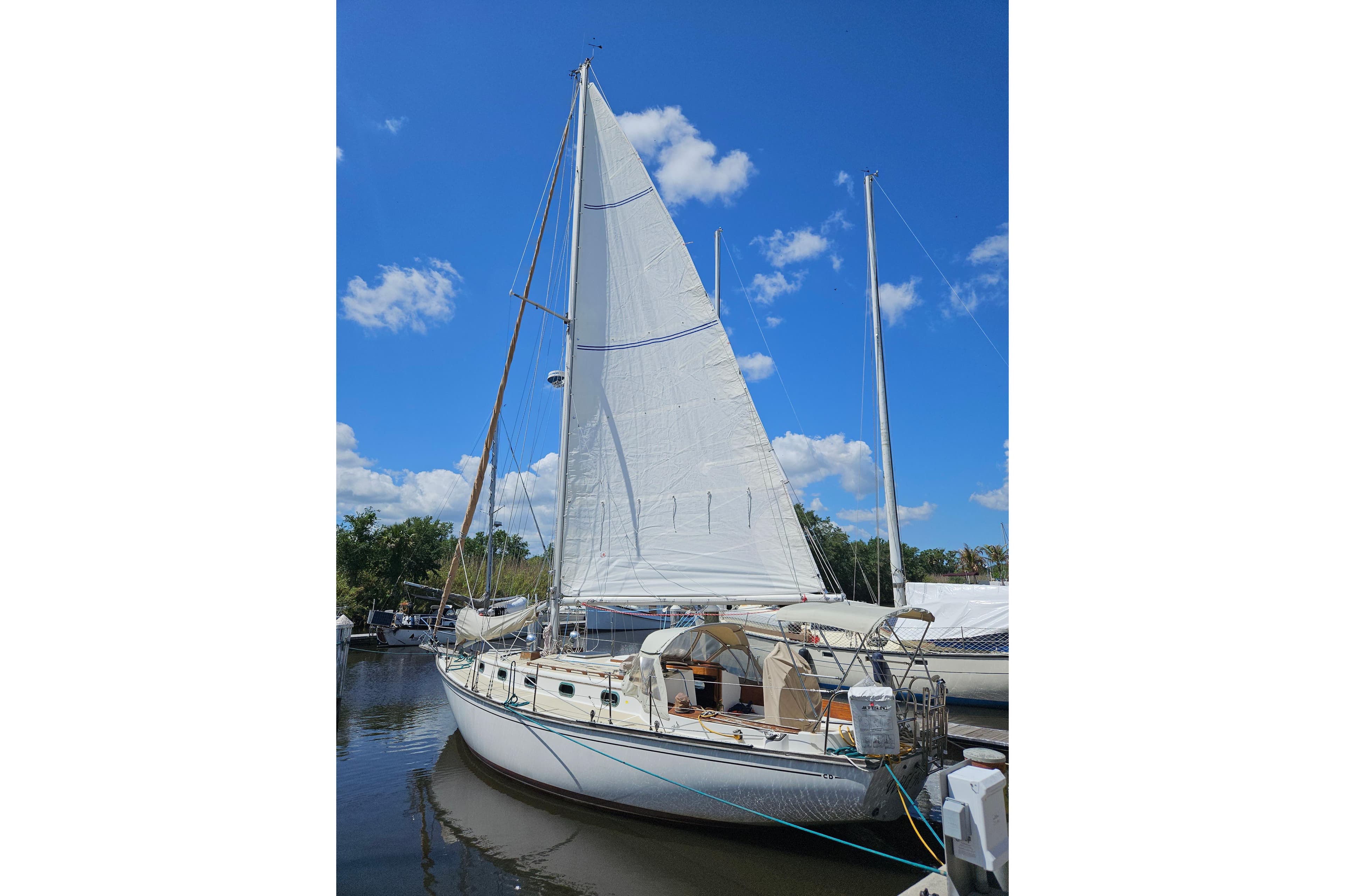 Sailboat Cape Dory 38, 1988 model, docked under a clear blue sky.