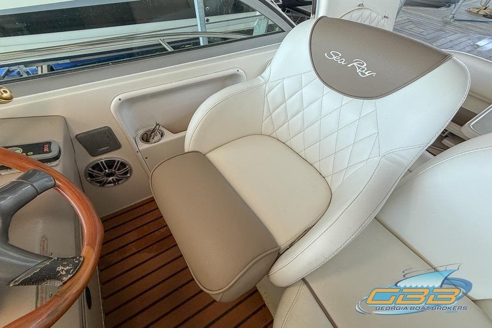 Captain's seat on 2000 Sea Ray 340 Sundancer boat with wood accents and logo.