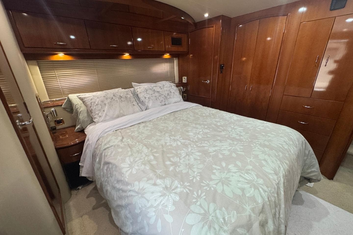 Luxurious bedroom interior of 2004 Carver 564 Cockpit Motor Yacht with elegant wood finishes.