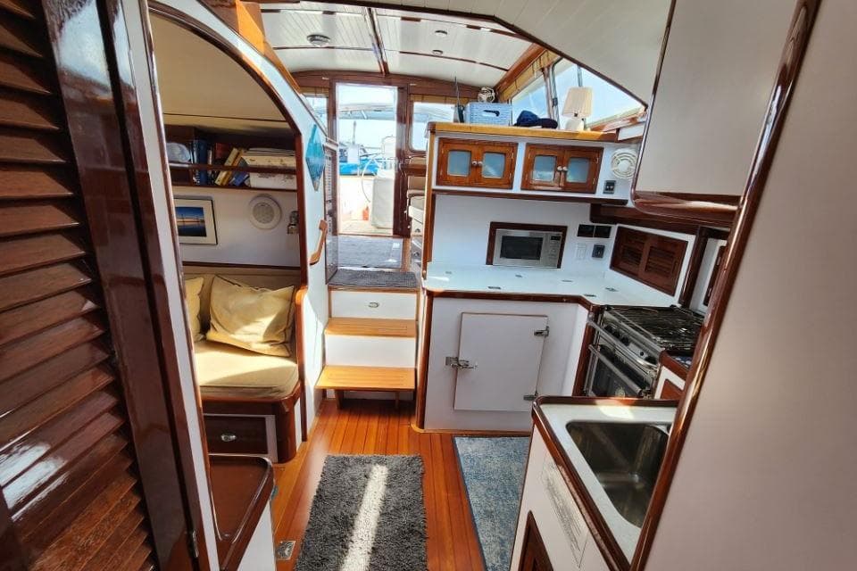 Luxurious 2008 Bruckmann 50 MKII yacht interior with wood finishes and modern kitchen amenities.