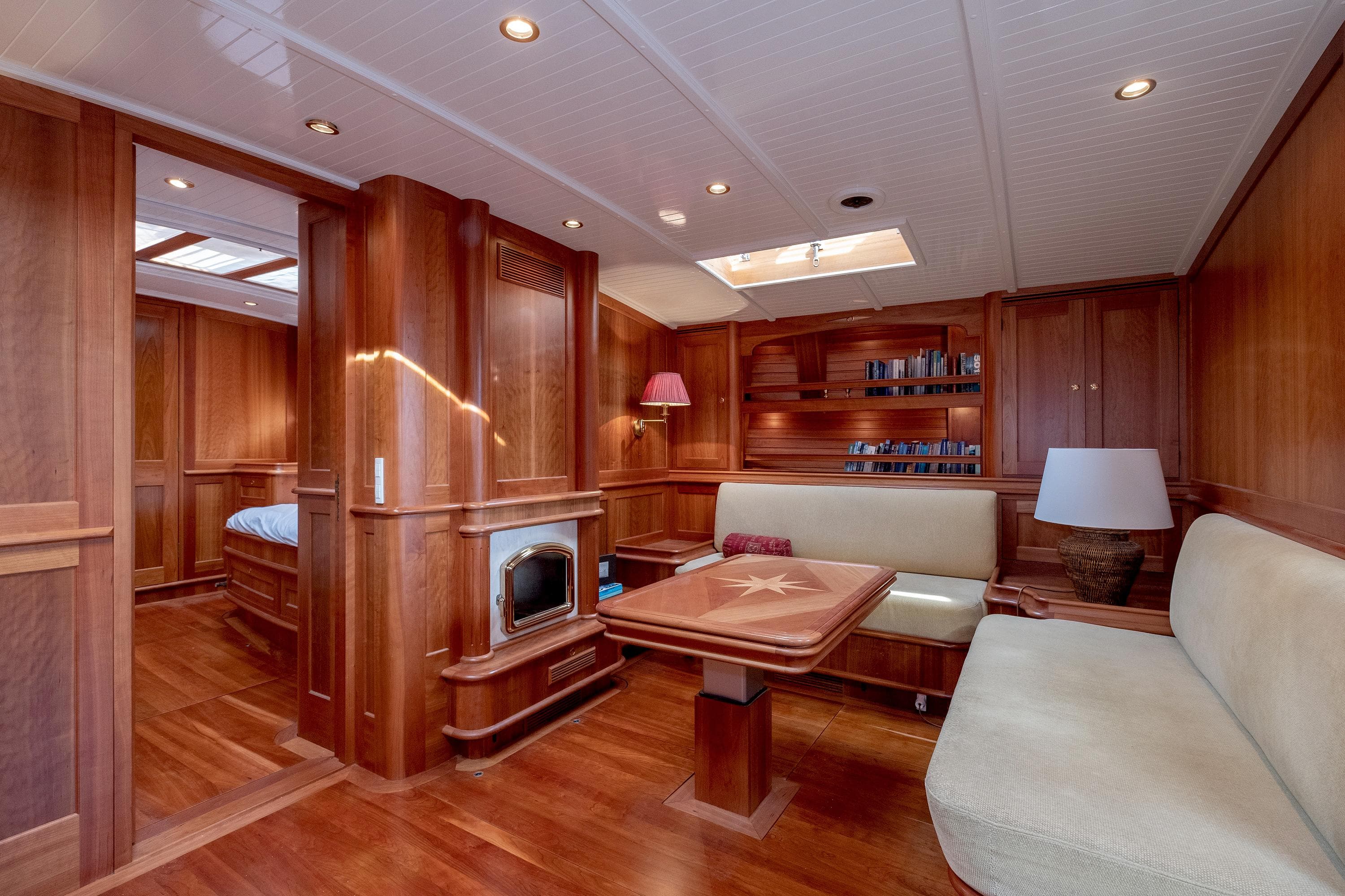 Luxurious wooden interior of 2004 Hoek Classic 73 yacht with elegant seating and lighting.