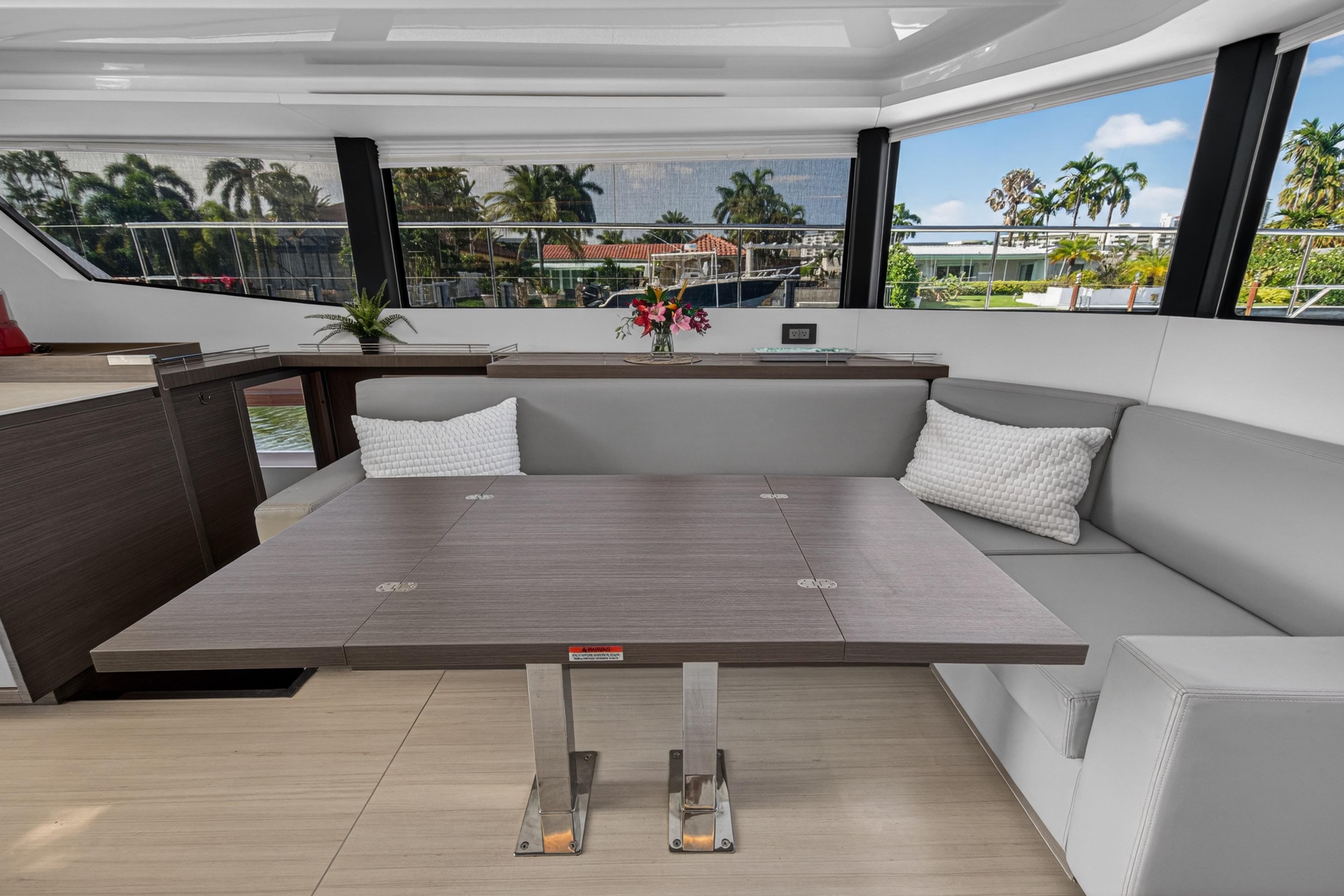 Luxurious interior of 2022 Leopard 53 Powercat yacht with modern seating and table.