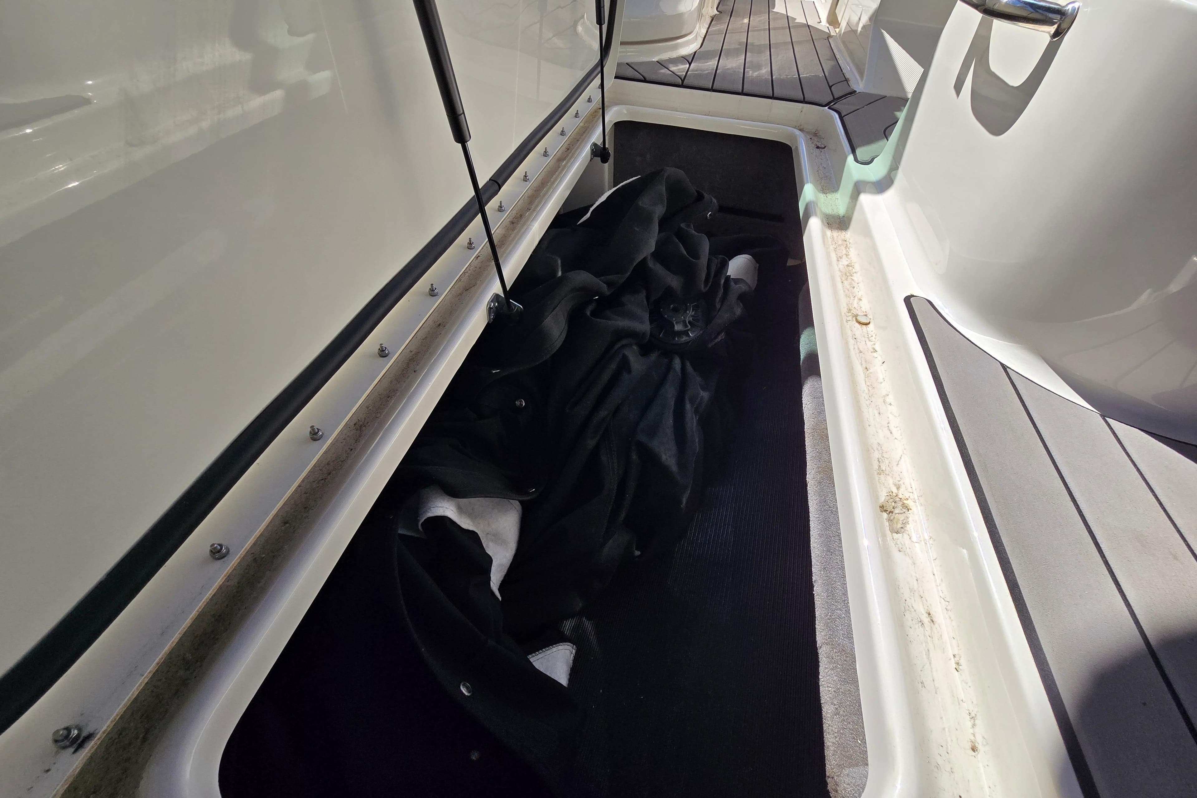 Storage compartment on a 2022 Sea Ray SLX 280 boat, featuring a black cover.