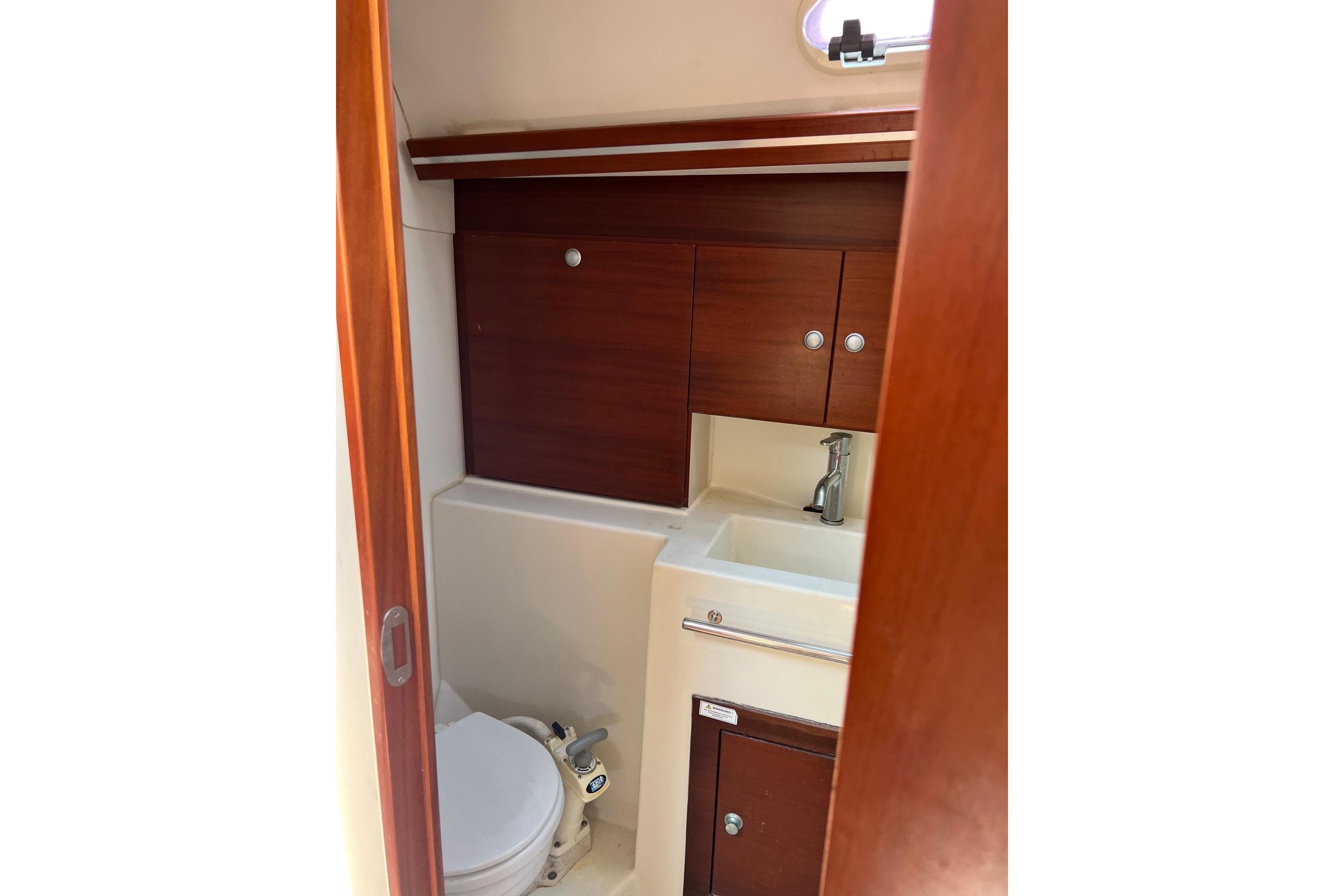 Compact bathroom in a 2007 Hanse 400e yacht with wooden cabinetry and modern fixtures.