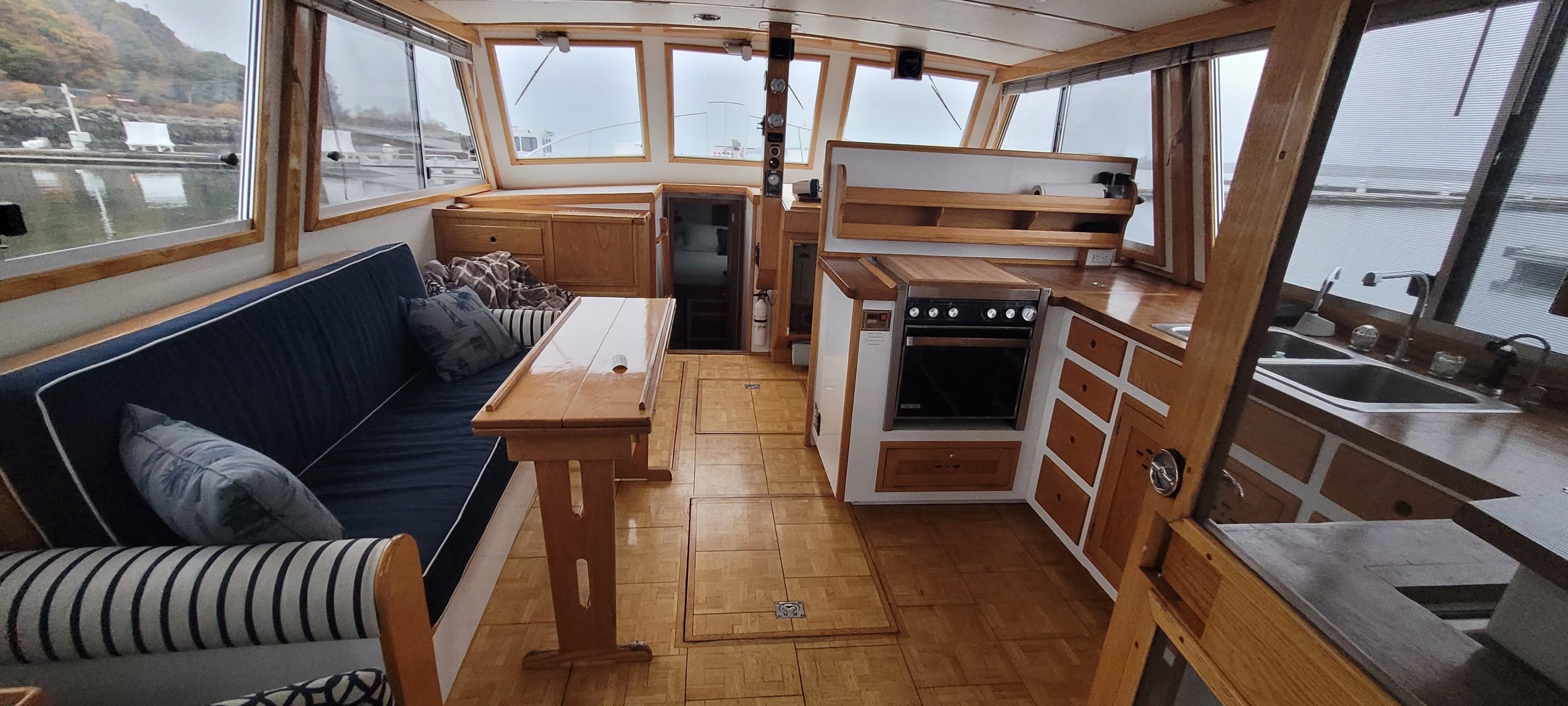 Interior of 1989 Duffy Wilbur 42 Flybridge Cruiser with cozy seating and kitchen area.