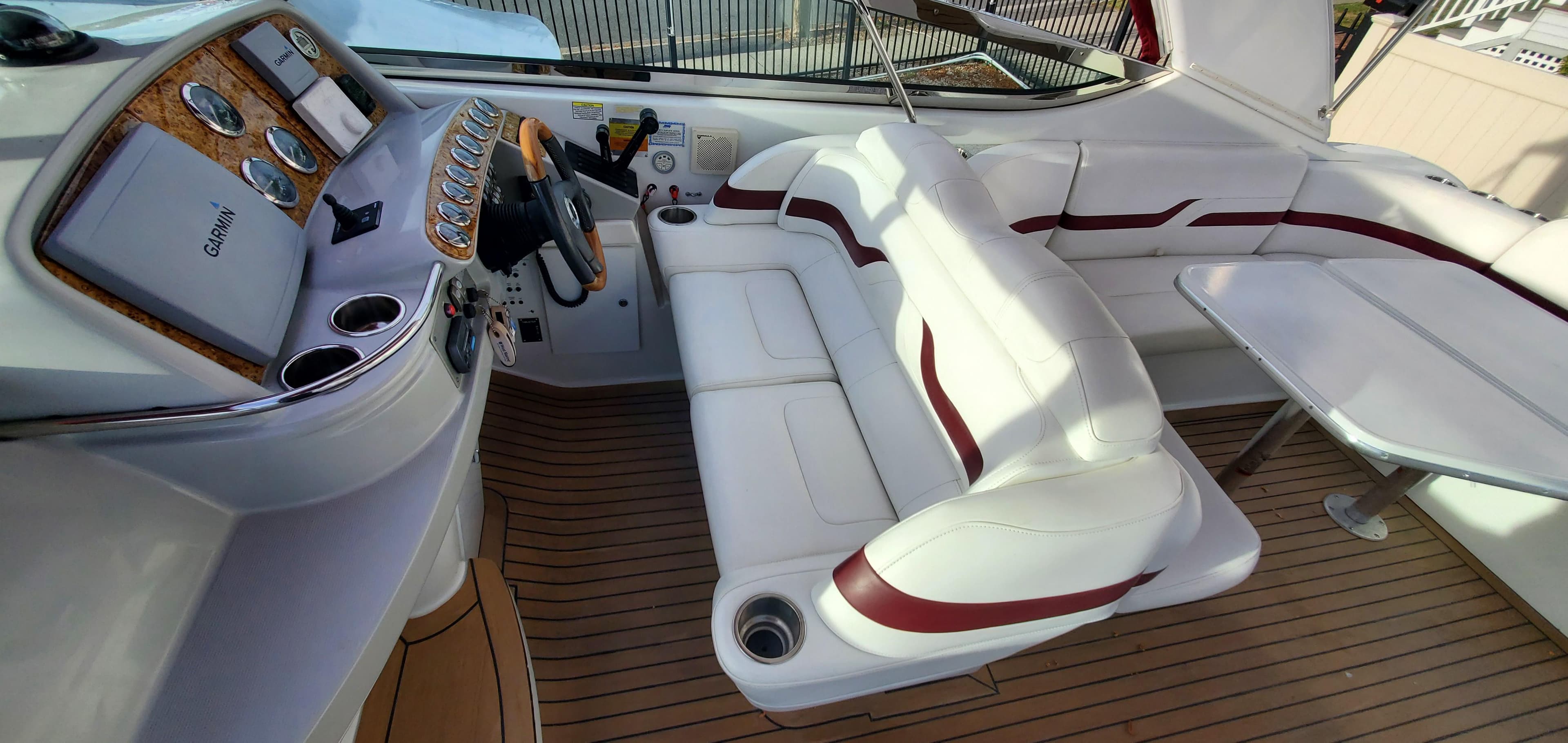 2007 Formula 370 Super Sport boat interior with white and red seating, wooden flooring, and control panel.