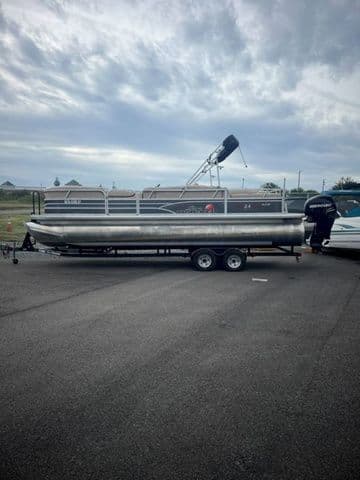 2015 Sun Tracker PARTY BARGE® 24 XP3 pontoon boat on trailer, parked outdoors.