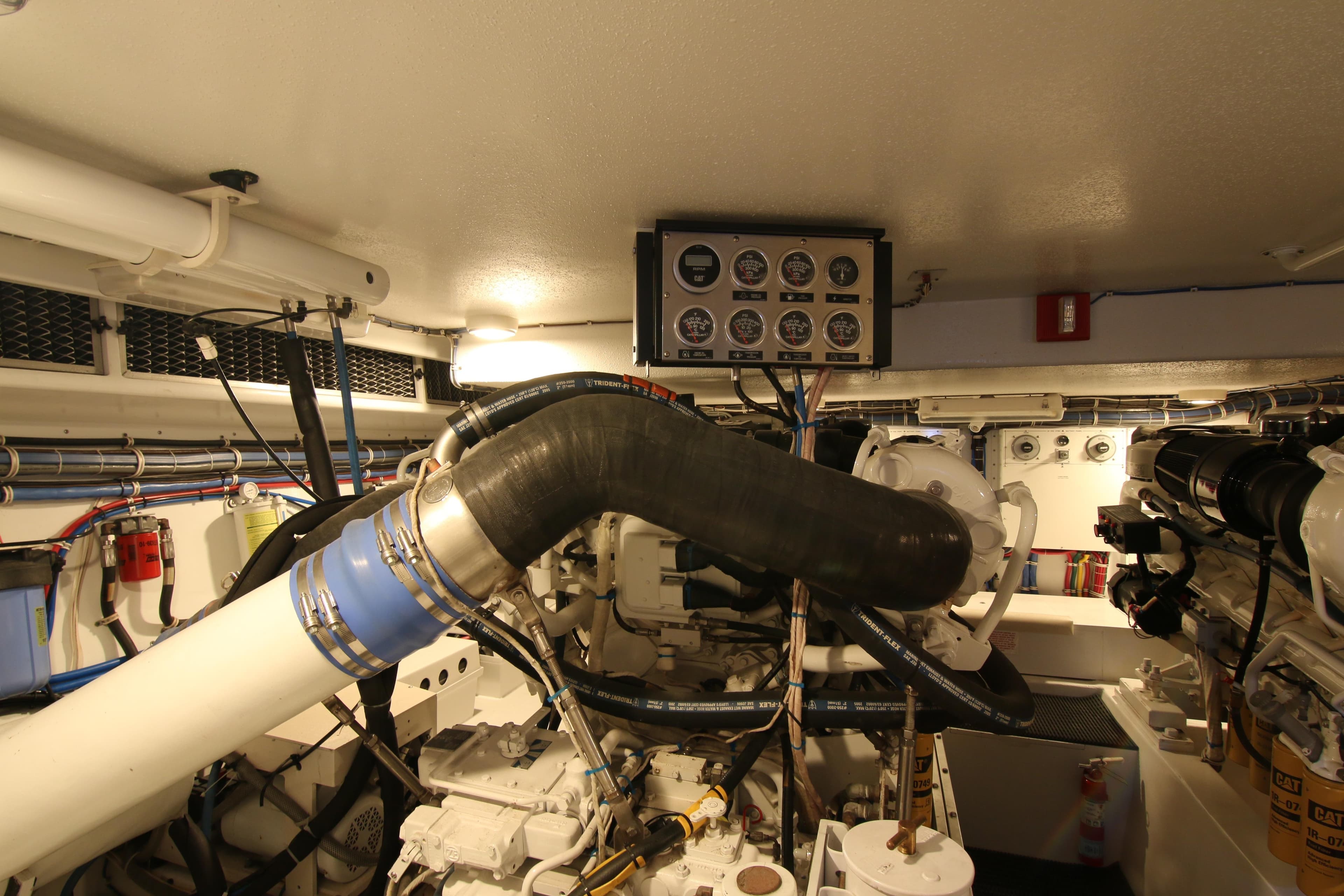 Engine room of 2002 Hatteras 63 Raised Pilothouse Motor Yacht with gauges and machinery.