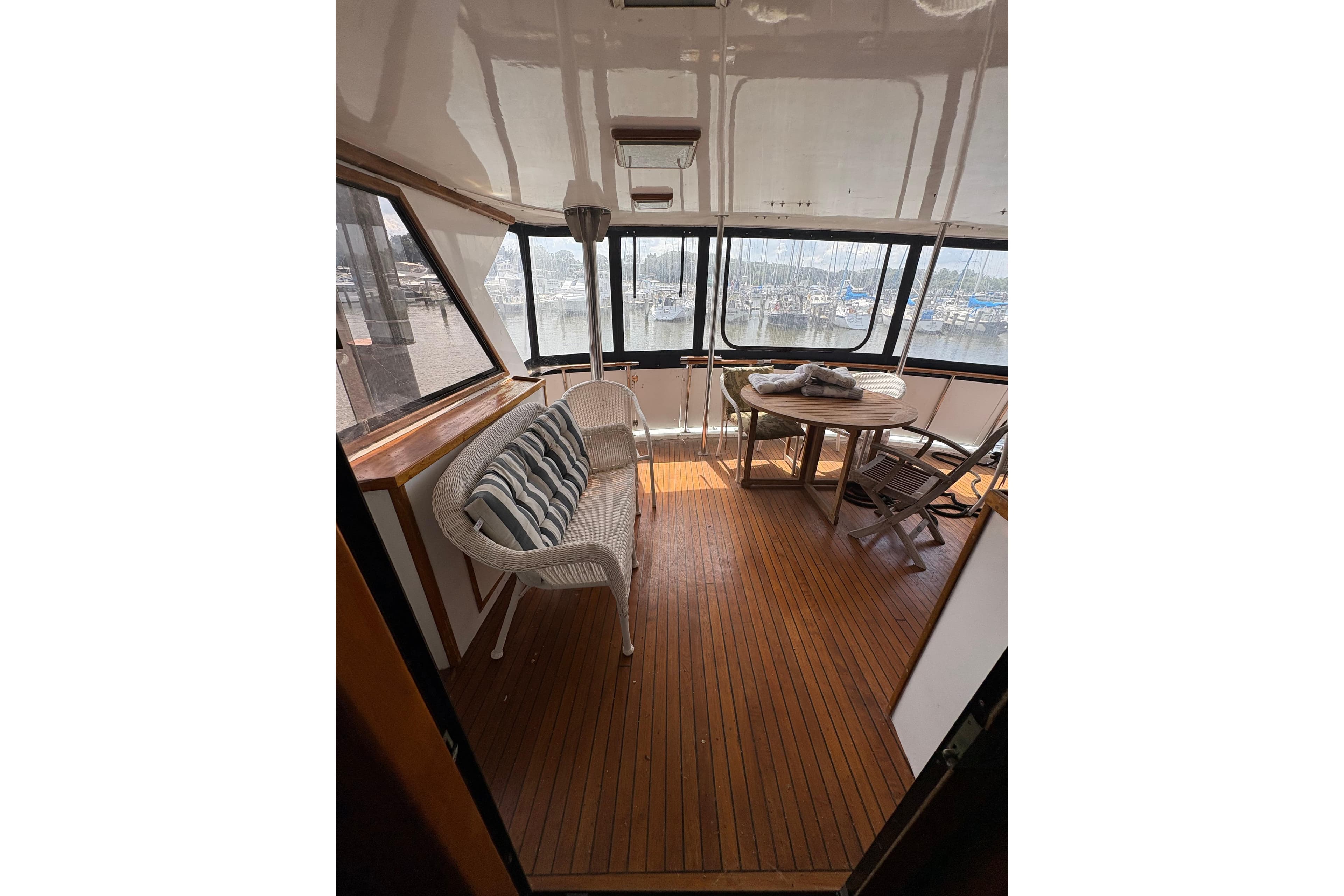 1989 Jefferson 60' Marquessa Motor Yacht interior with wicker seating and wooden flooring.