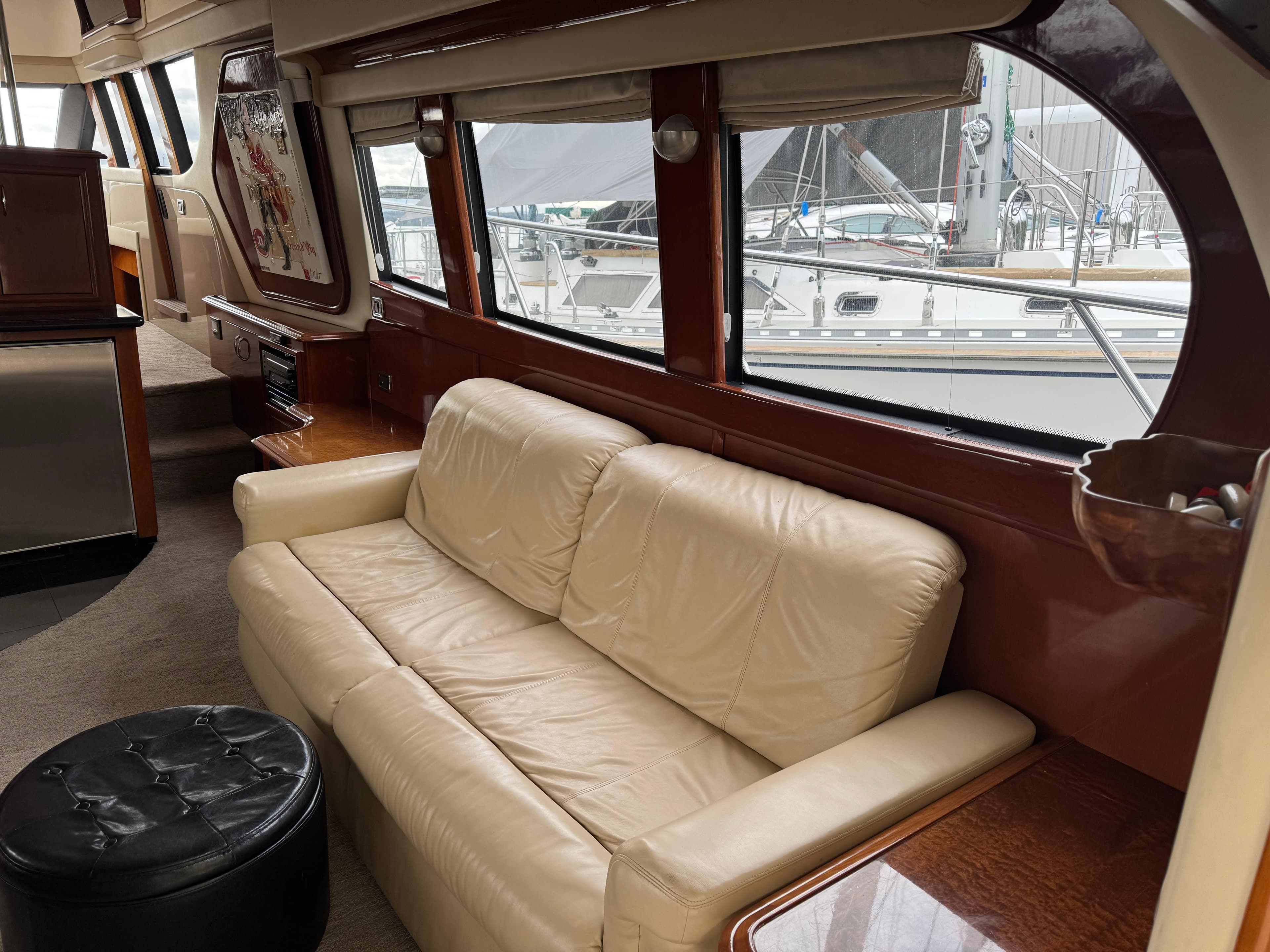 Luxurious interior of 2005 Carver 560 Voyager yacht with cream leather sofa and large windows.