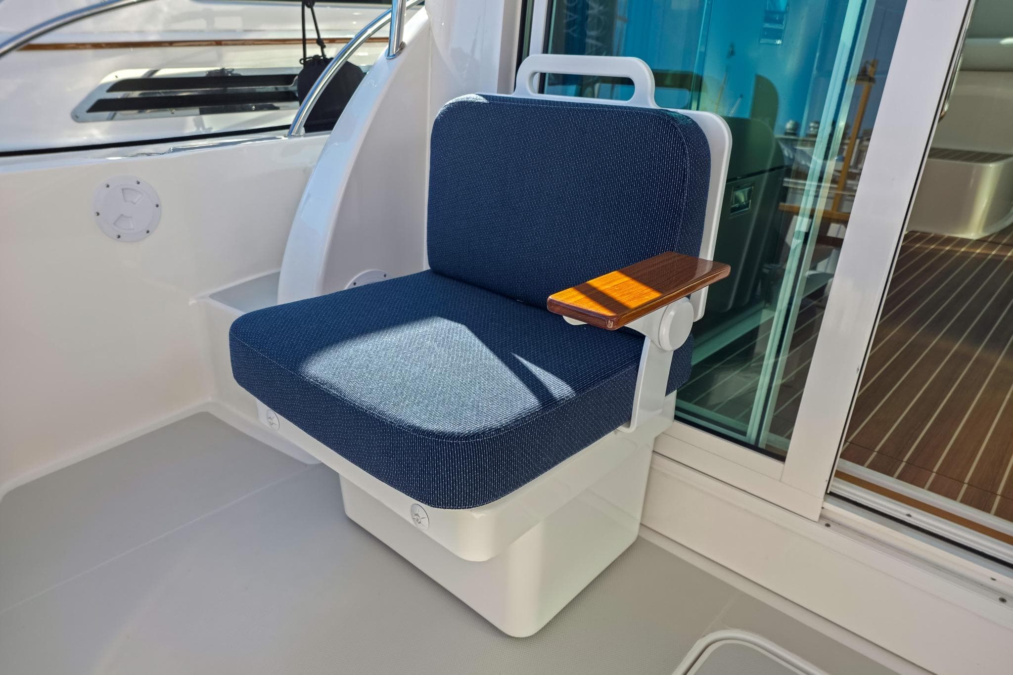 2026 Back Cove 412 boat seat with blue upholstery and wooden armrest.