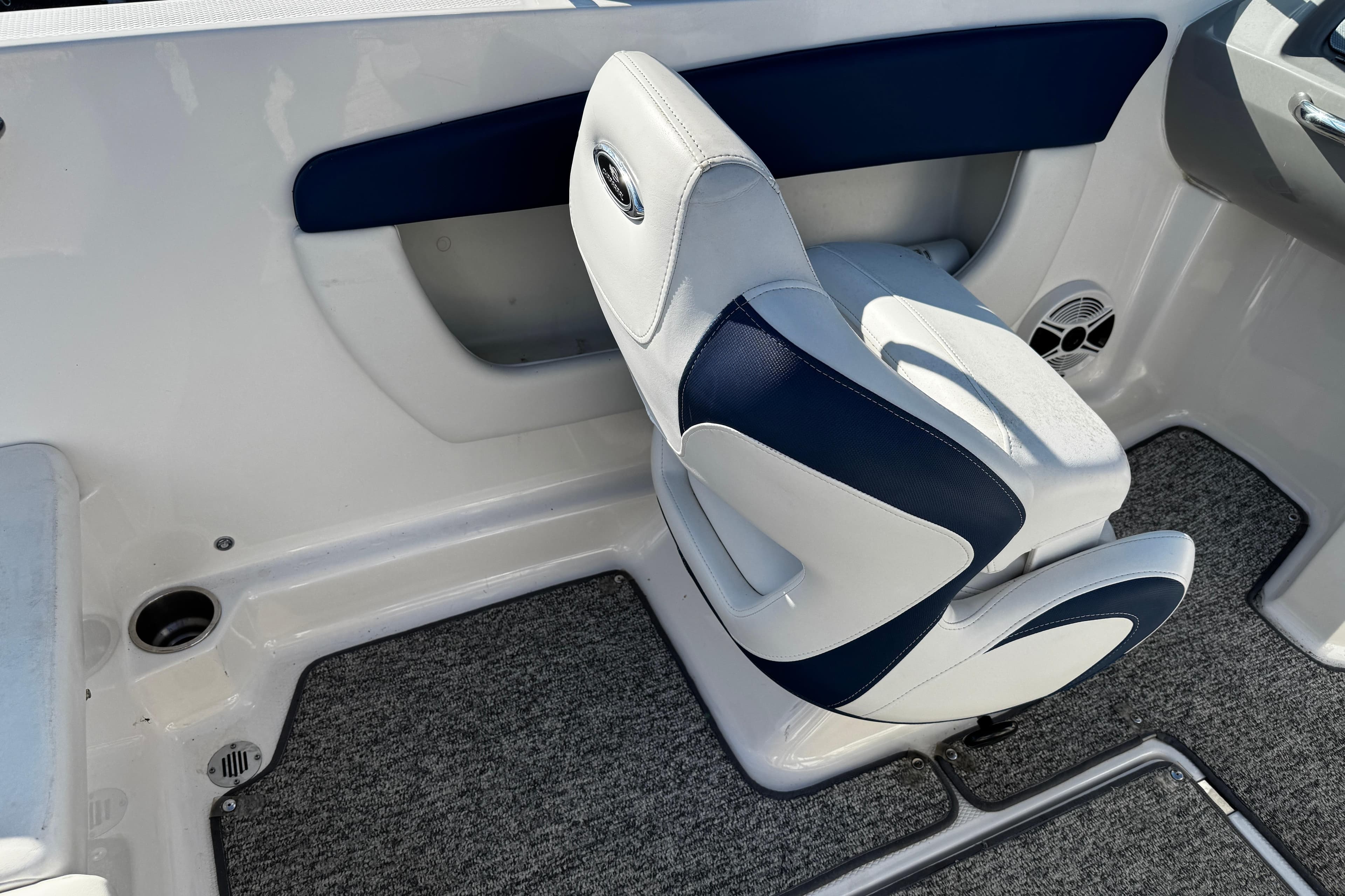 Interior of 2015 Chaparral 19 H2O Sport boat with cushioned seating and carpeted flooring.