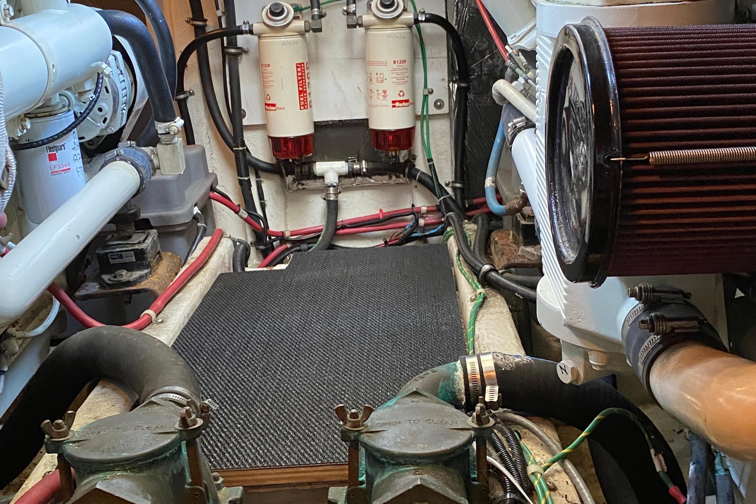 Engine room of 2001 Bayliner 4087 Aft Cabin Motoryacht with visible filters and hoses.