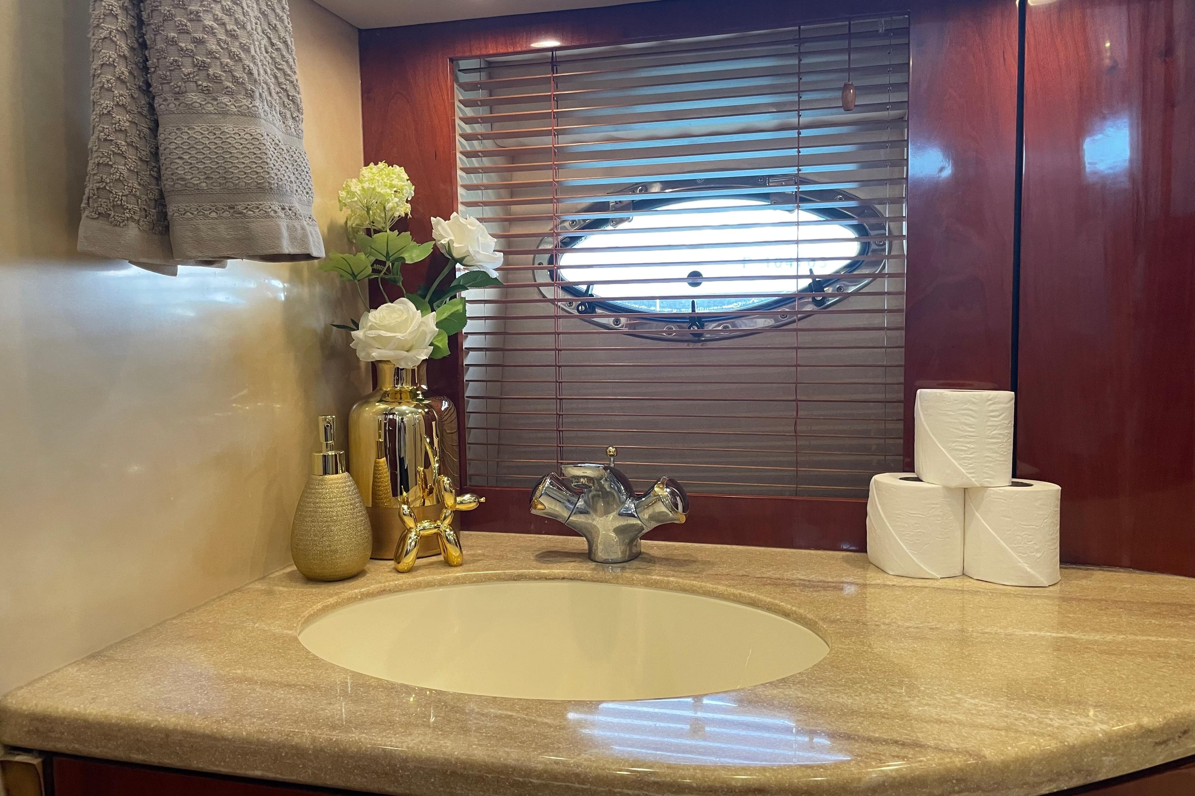 Luxurious bathroom on 2001 Fairline Squadron 58 yacht with elegant decor and porthole window.