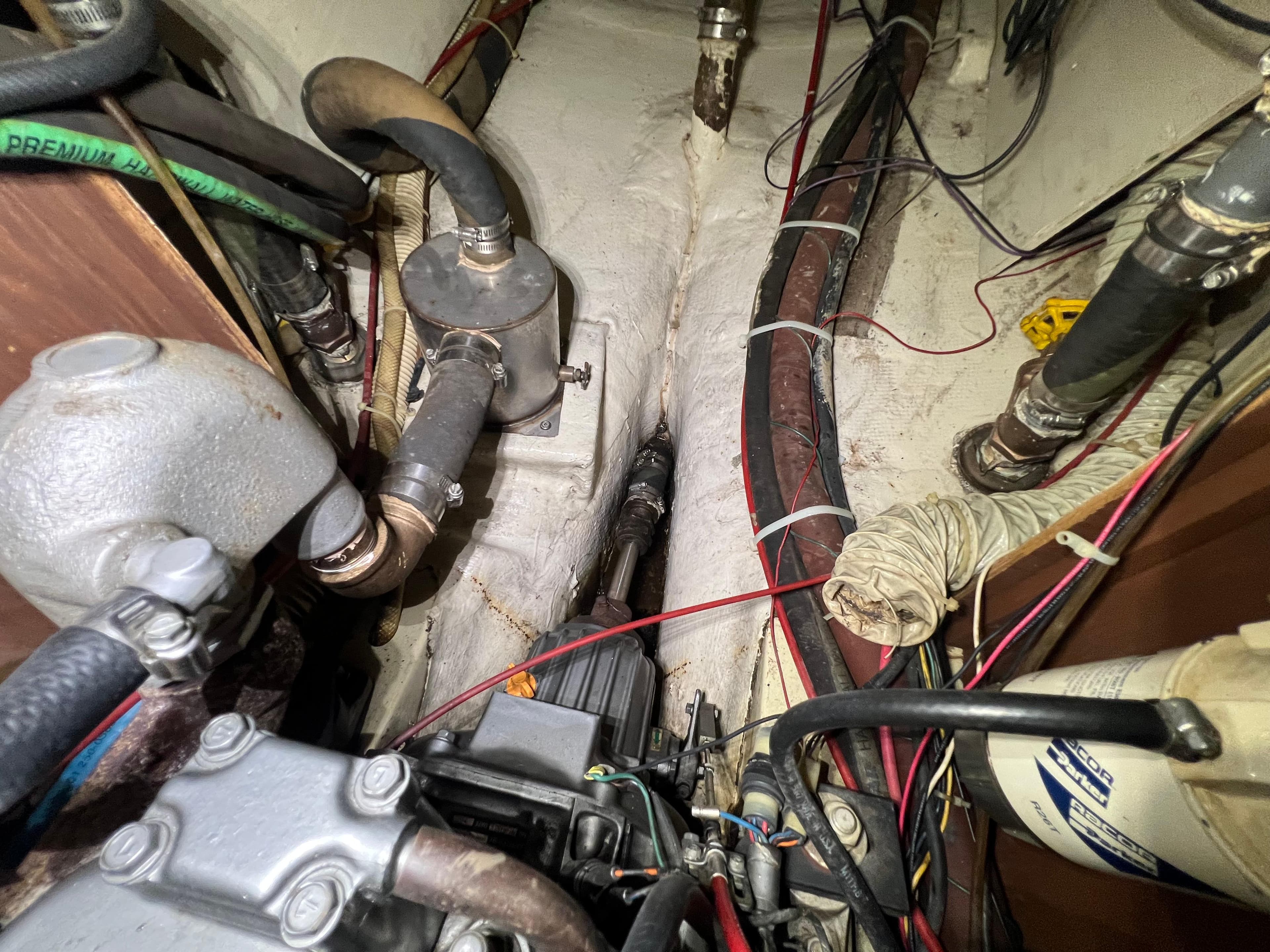Engine compartment of a 1987 Bayfield 32C sailboat with visible hoses and wiring.