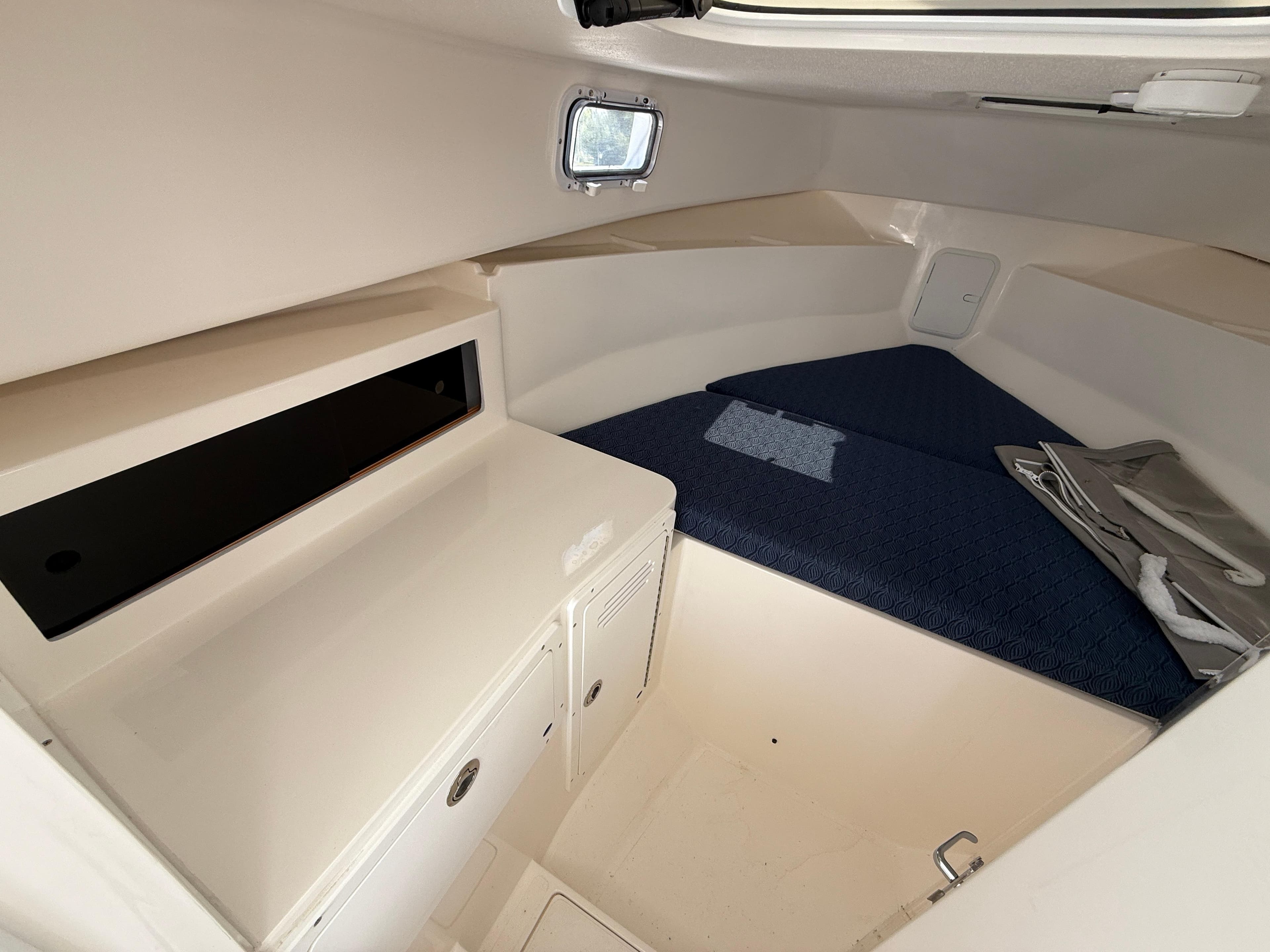 2025 NorthCoast 255 HT cabin interior with blue bedding and storage cabinets.
