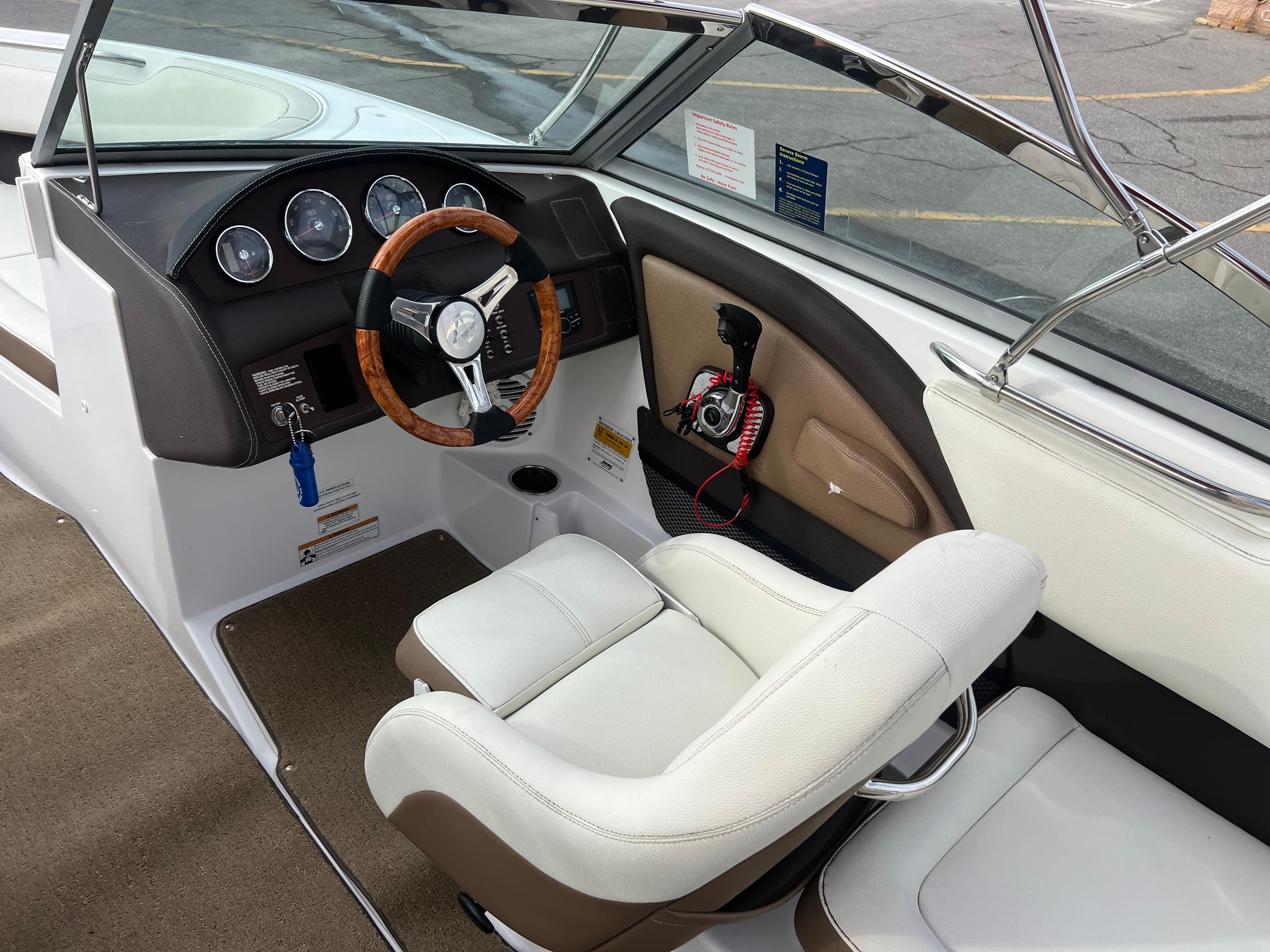2017 Cobalt 220S boat interior with steering wheel and captain's chair.