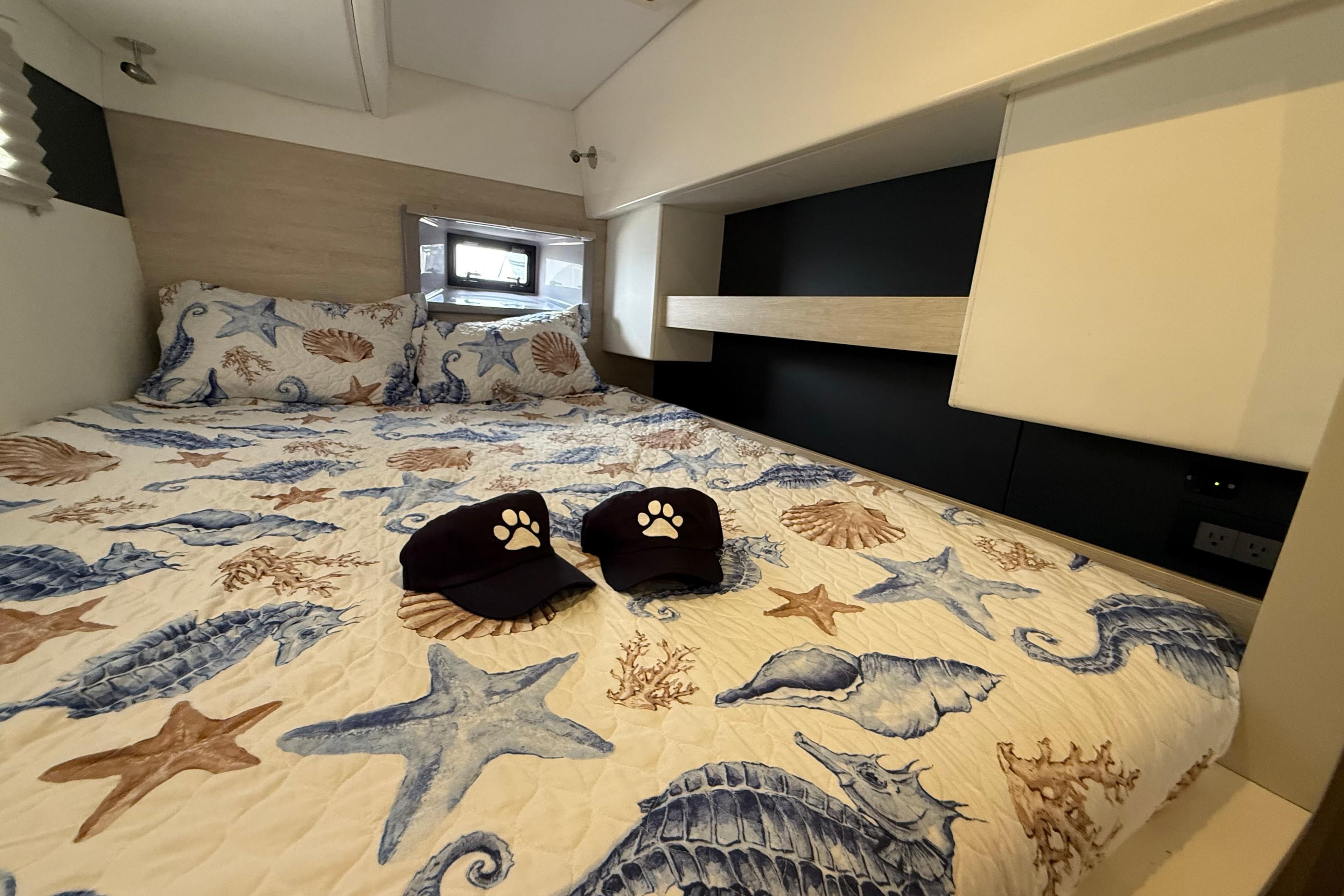 Cozy cabin interior of 2021 Leopard 43 Powercat with nautical-themed bedding.