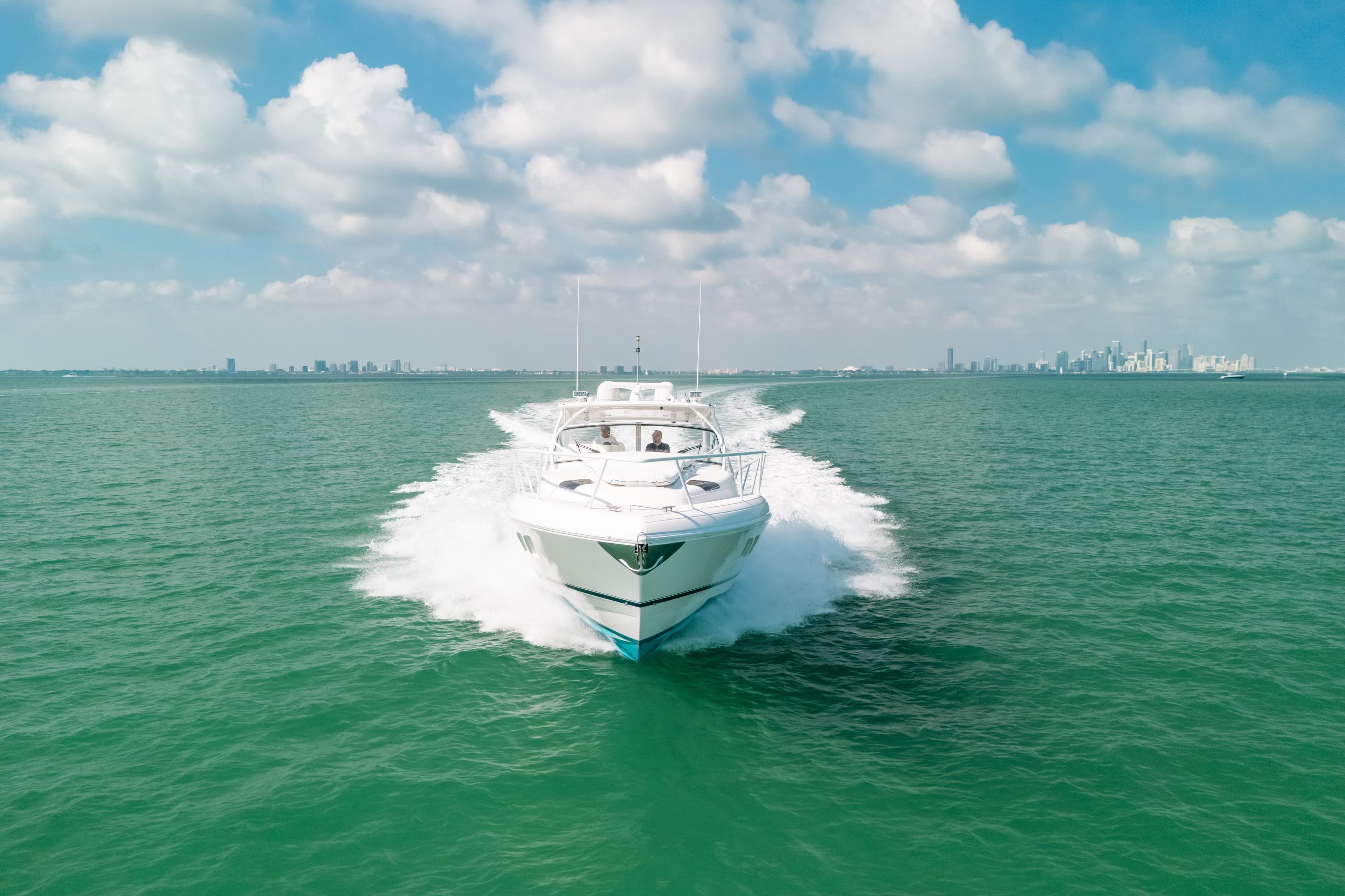 2009 Intrepid 475 Sport Yacht cruising on open water under a partly cloudy sky.