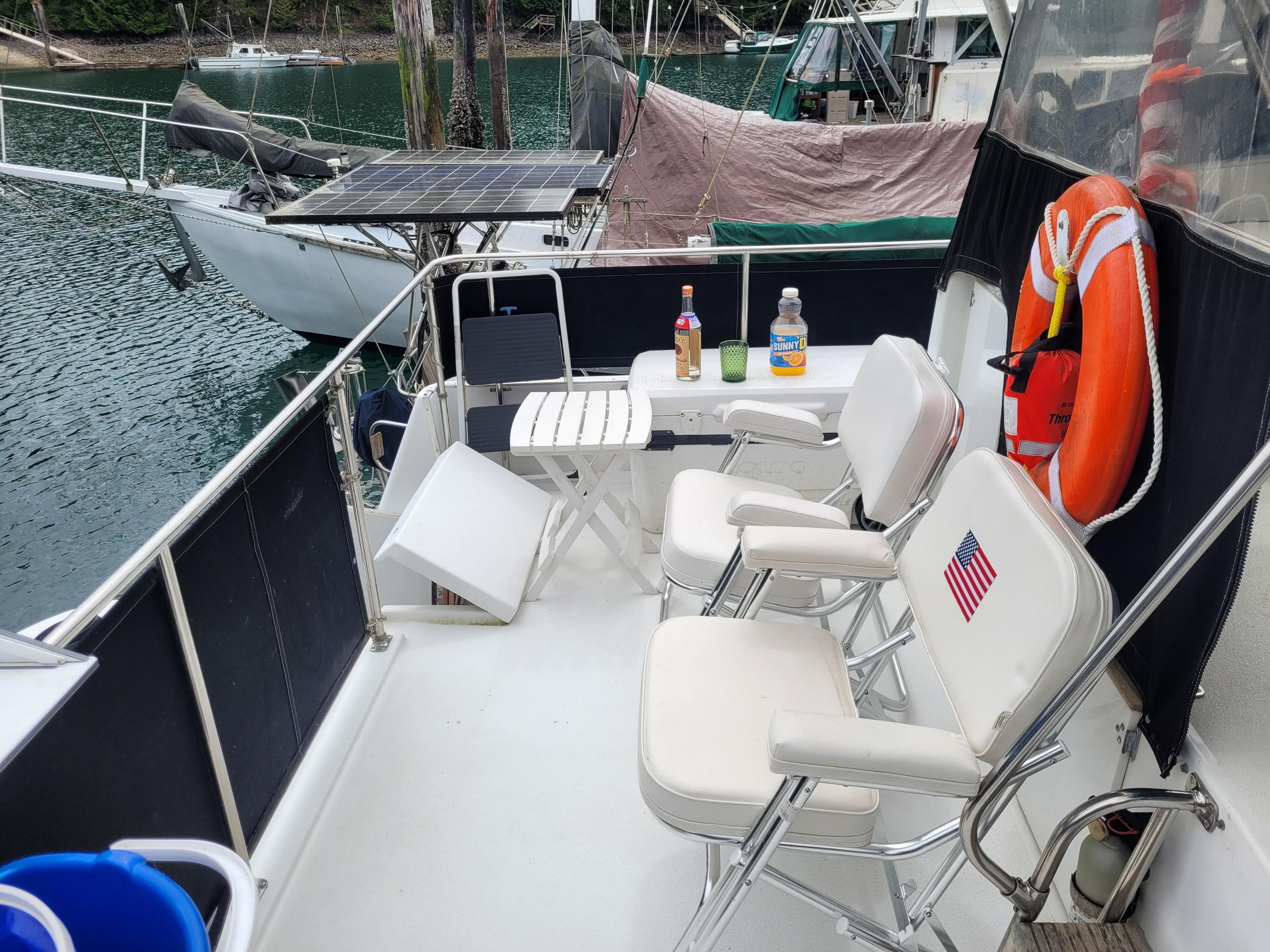 1991 Tollycraft Euro Sport Sedan deck with chairs, table, and life preserver.