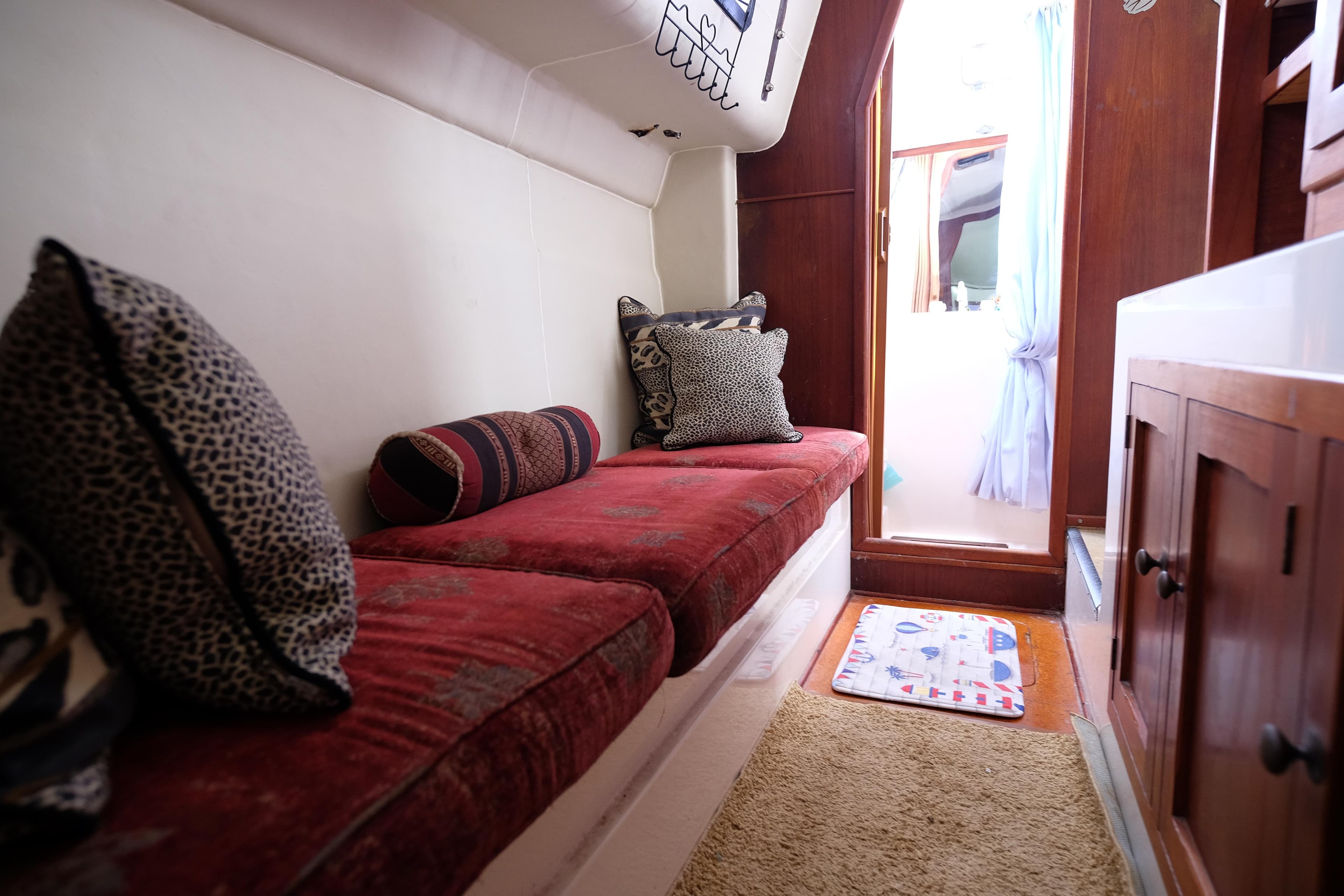 Cozy 1996 Simpson Inspiration yacht interior with red cushions and decorative pillows.