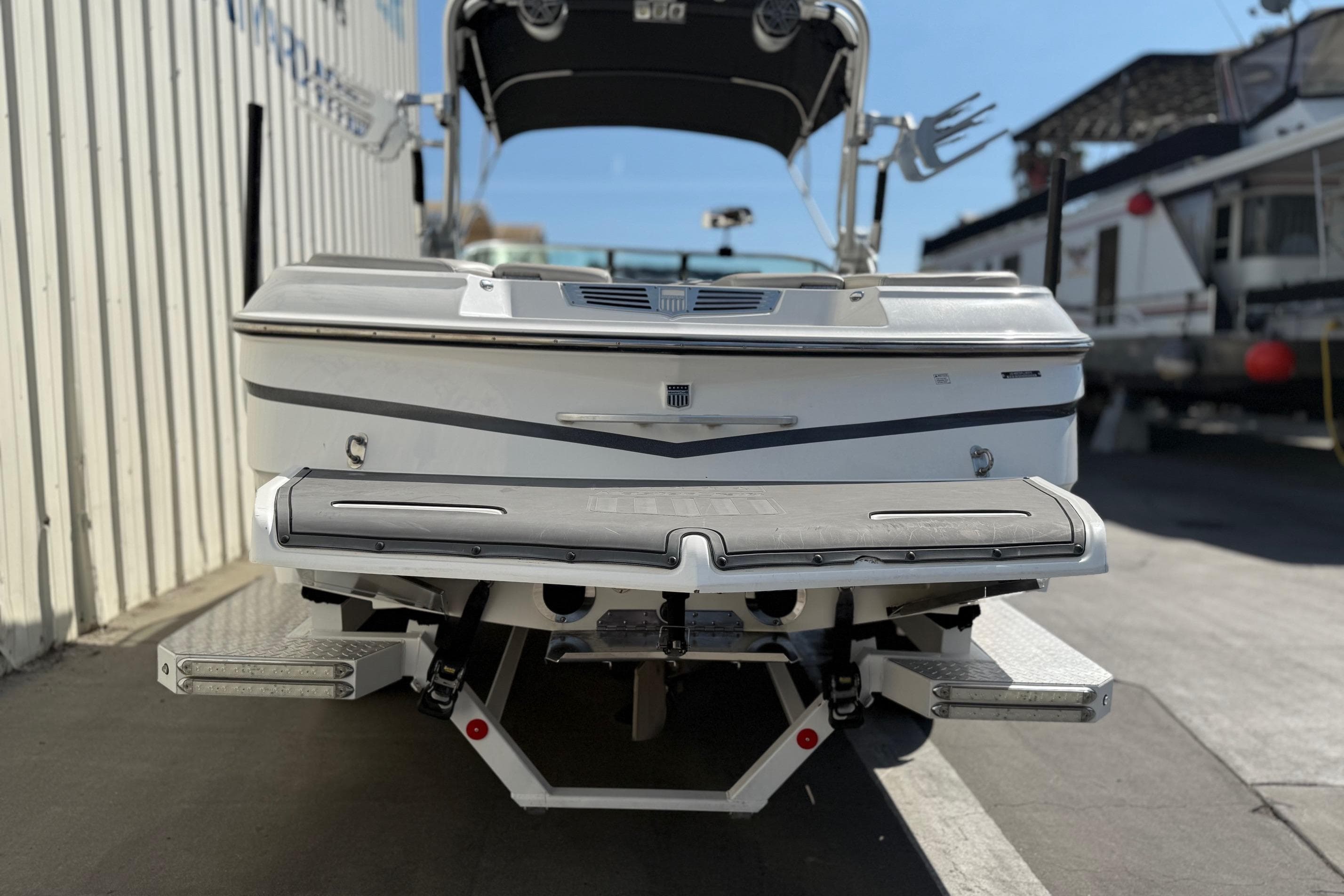 2015 MasterCraft X30 boat rear view in a marina setting.