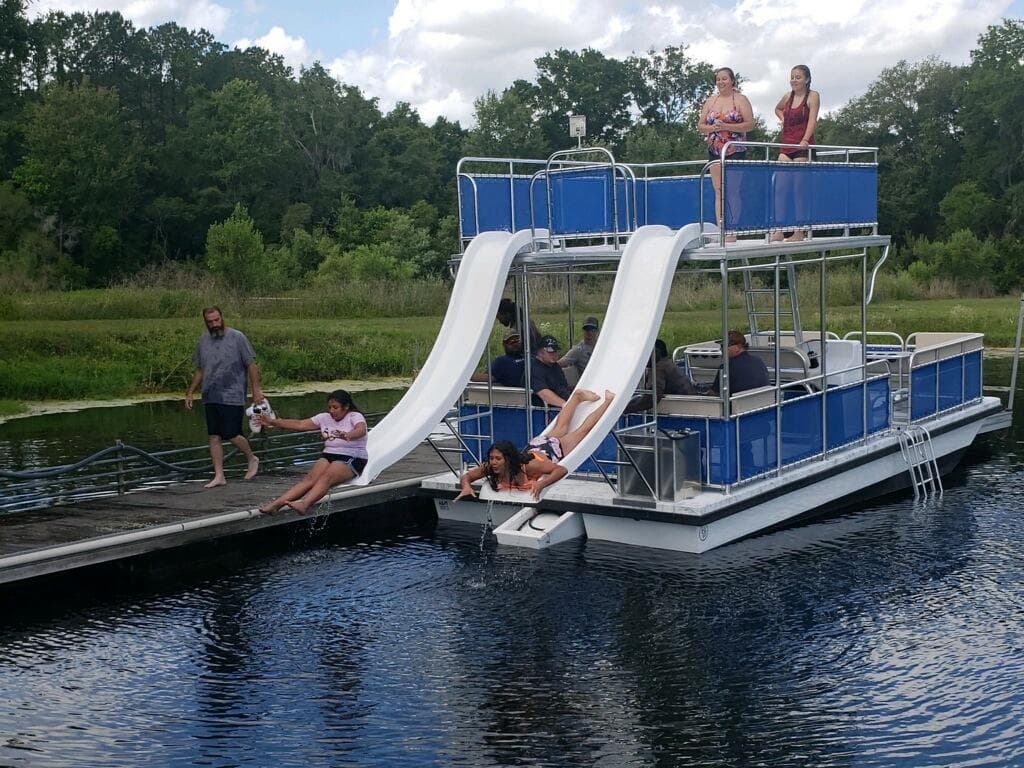 A&M Manufacturing Salty 28 DS boat with slides, people enjoying water activities, 2026 model.