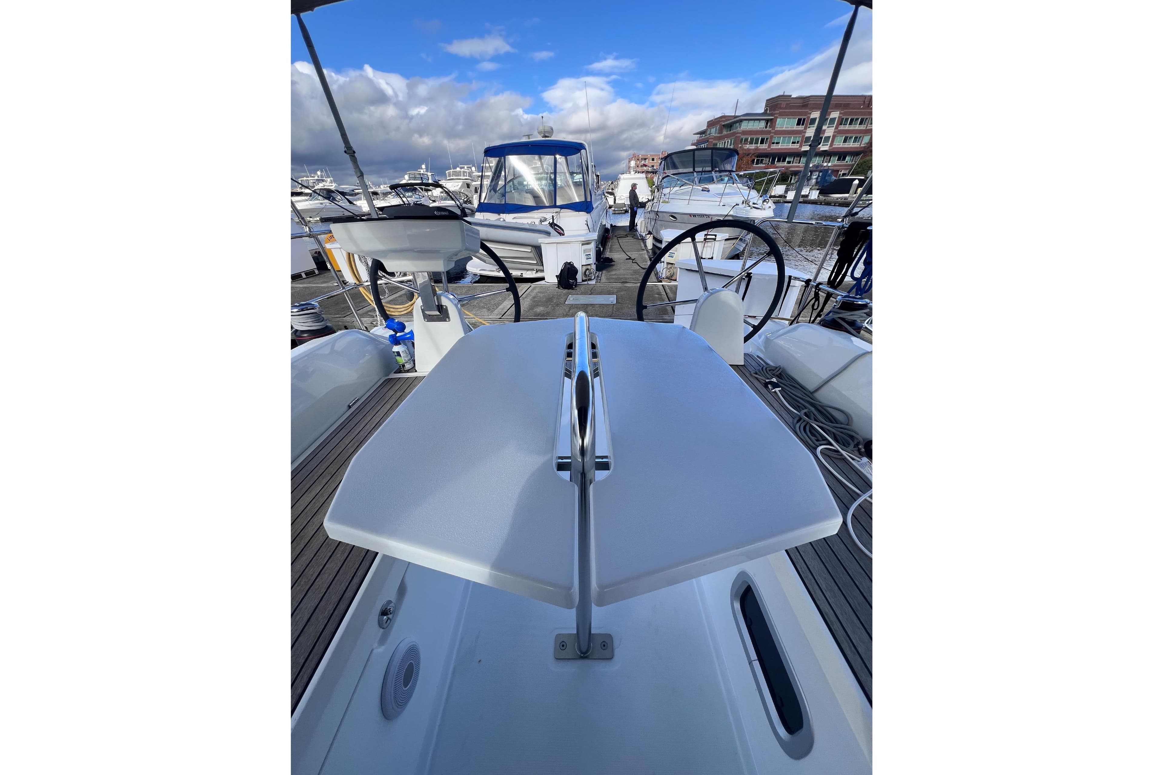 2024 Beneteau Oceanis 30.1 yacht deck with steering wheel and marina view.