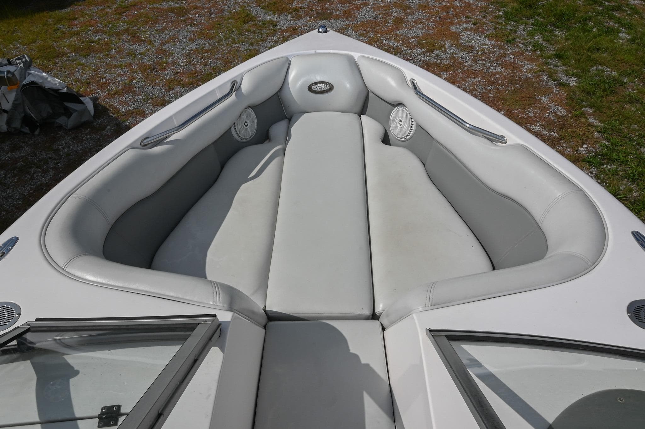 2004 Supra Launch SS boat interior with white cushioned seating and speakers.