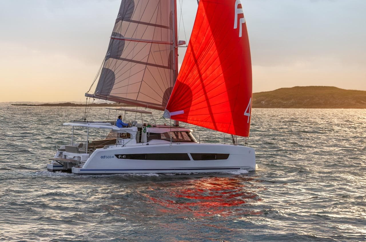 Sailing catamaran Fountaine Pajot NEW 41, 2026 model, with vibrant red sails at sunset.