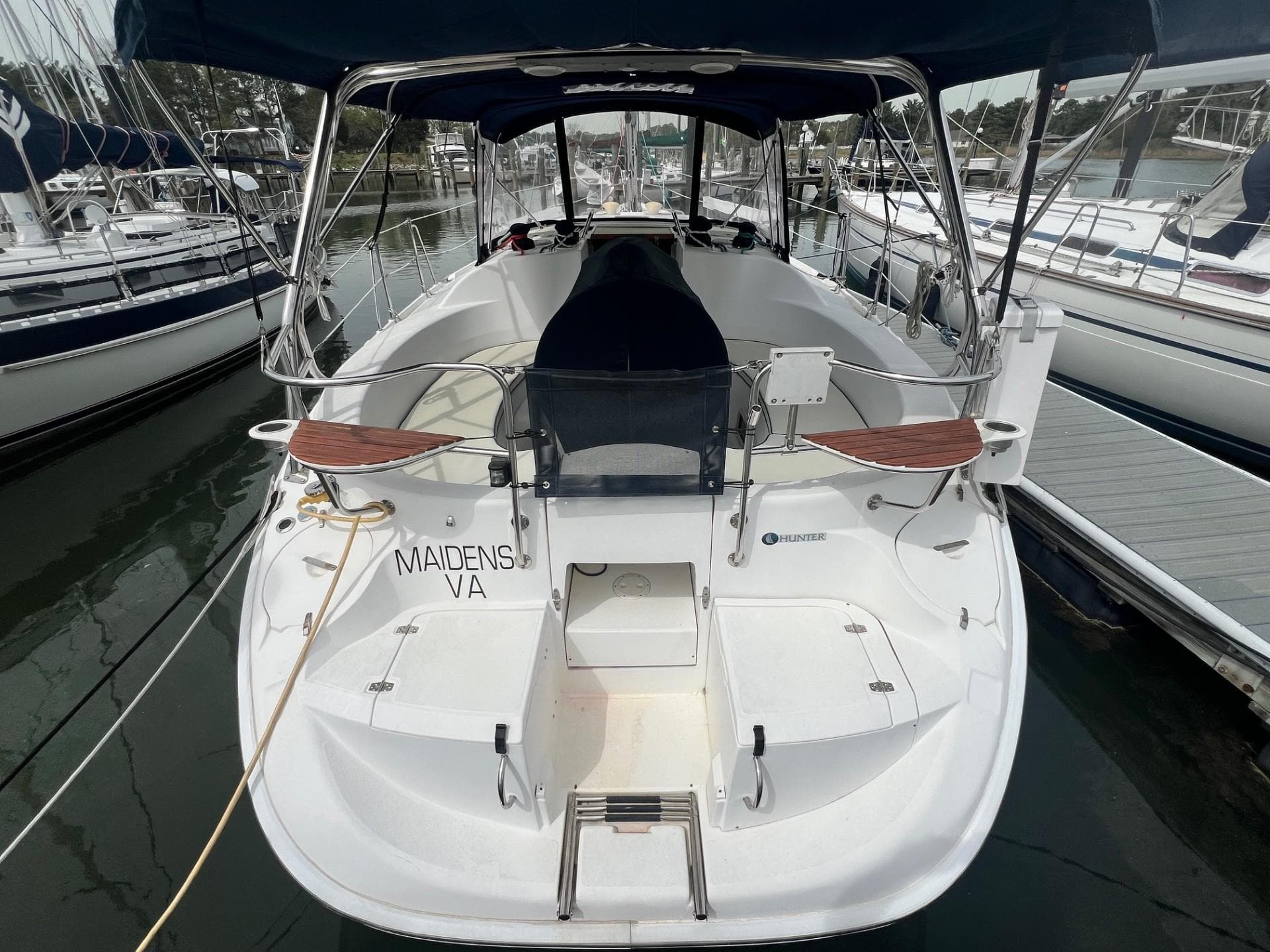 Hunter 386 sailboat, 2002 model, docked at marina with visible cockpit and seating area.