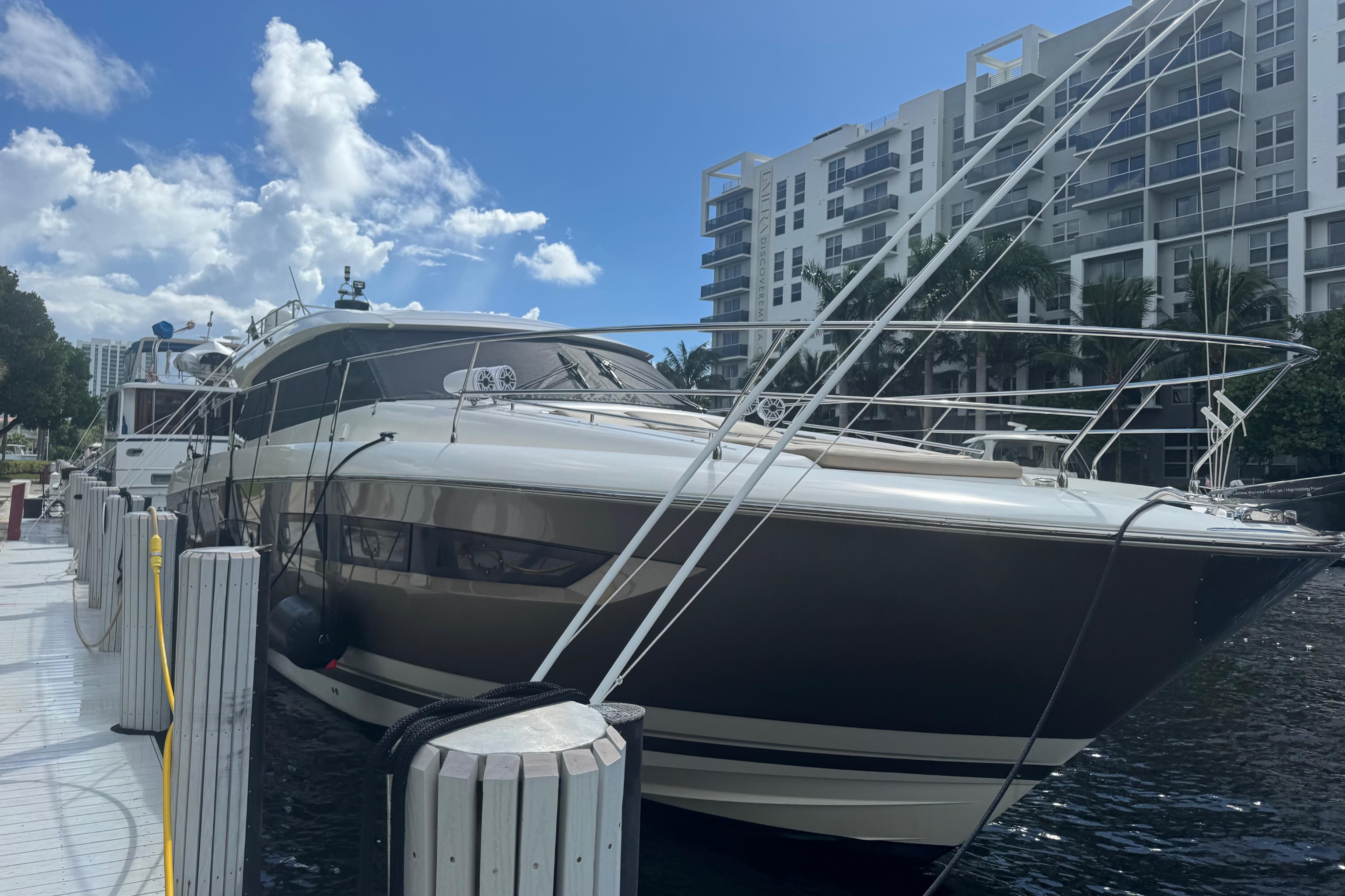 Luxury 2013 Prestige 550 S yacht docked near modern waterfront buildings.