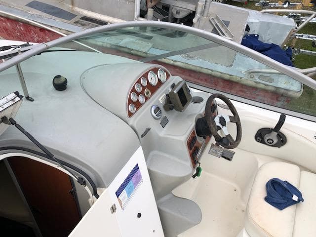 2007 Bayliner 275 boat cockpit with steering wheel, gauges, and seating.