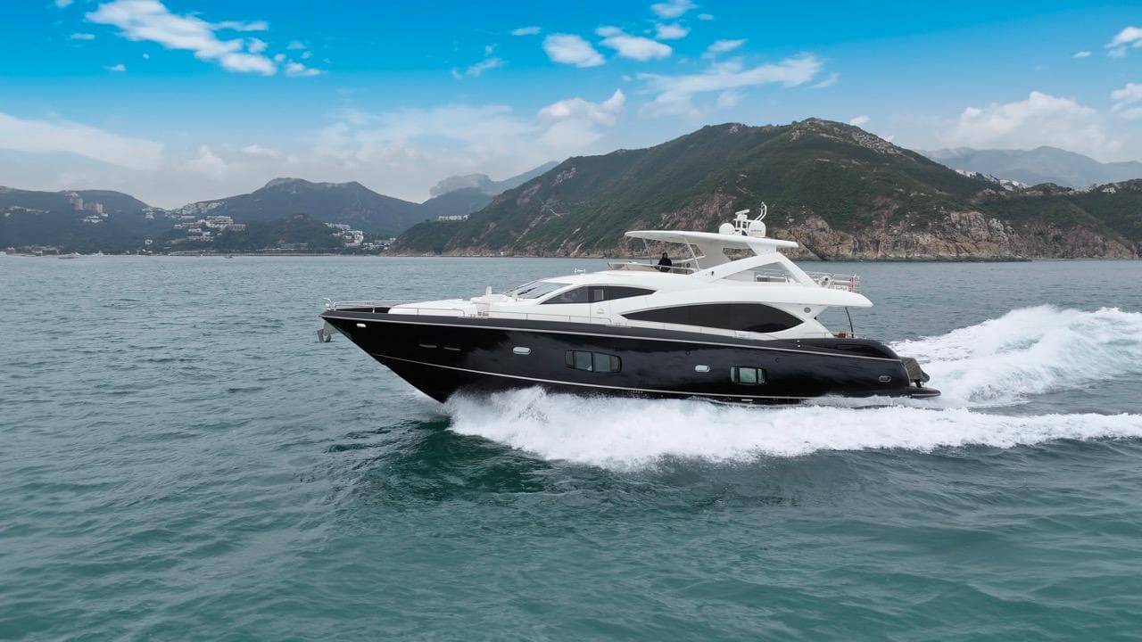 Sunseeker 86 Yacht 2009 cruising on open water with scenic mountain backdrop.