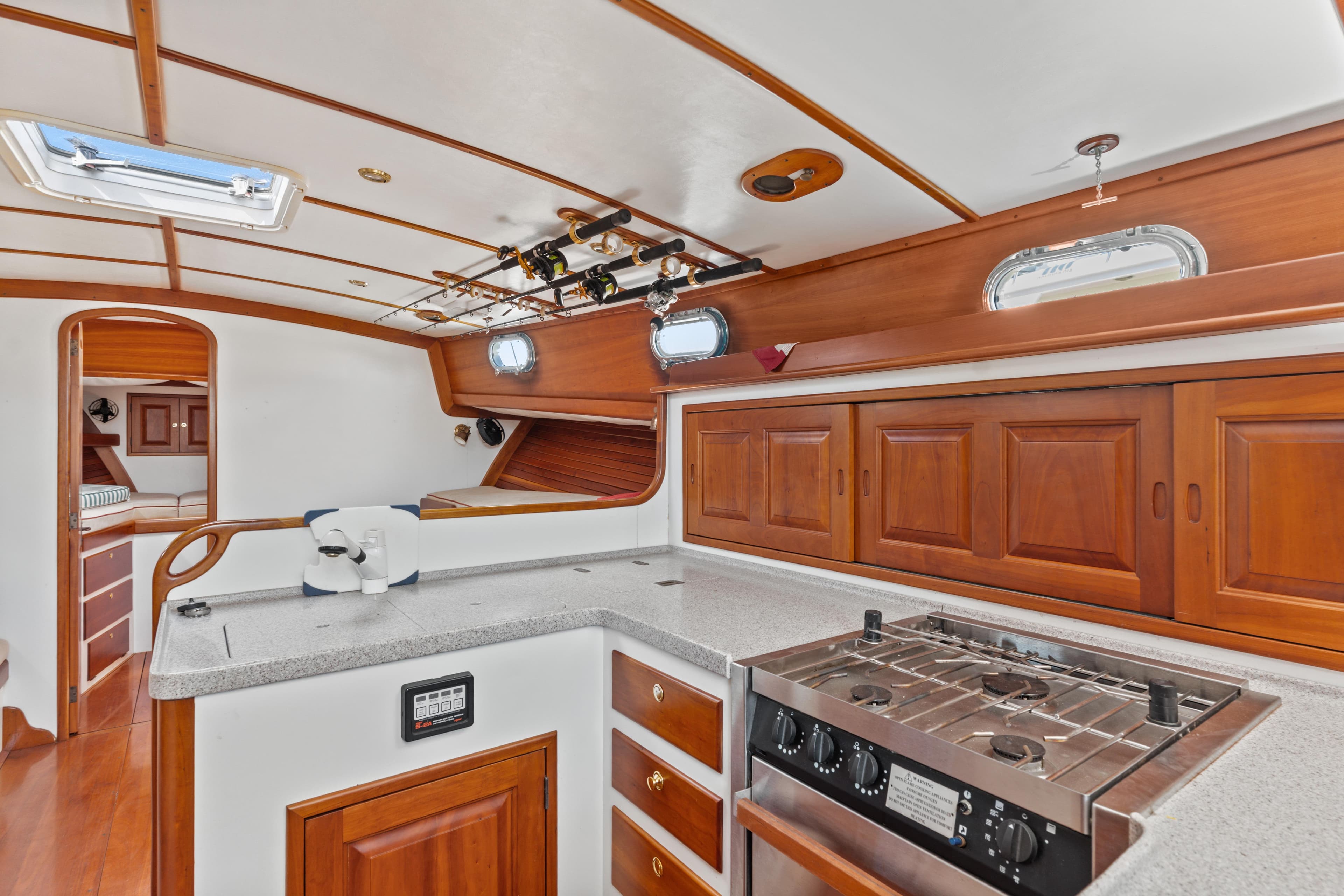 Luxurious 1999 Able 44 yacht interior with wooden cabinetry and modern kitchen amenities.