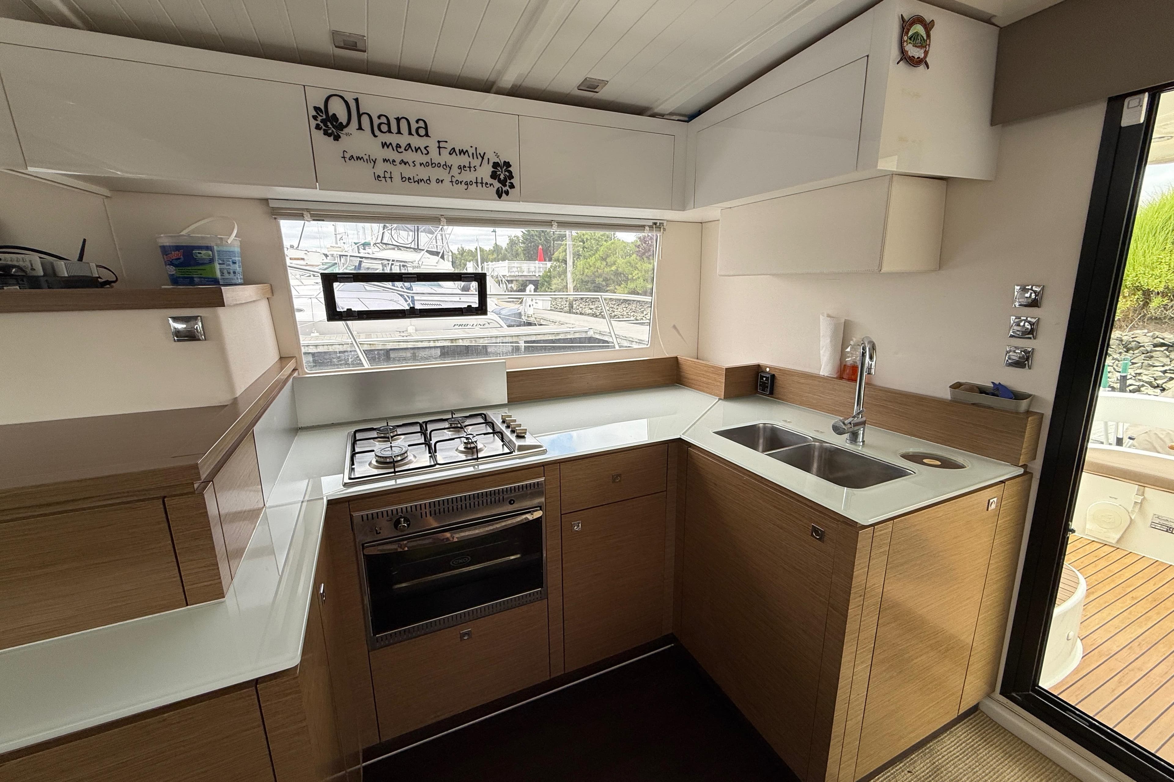 Modern kitchen in 2015 Fountaine Pajot Summerland 40 LC yacht with stove and sink.