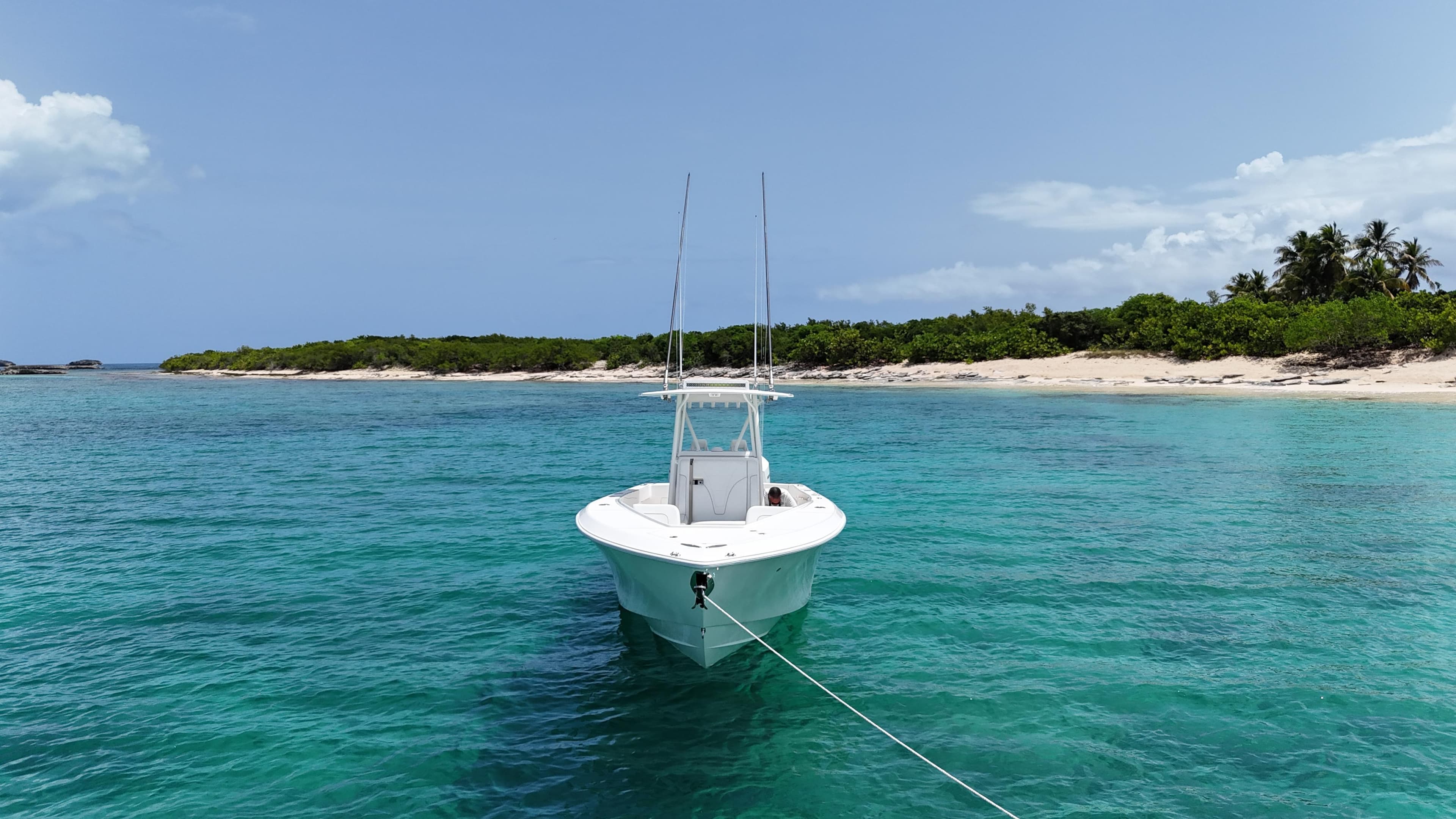 2024 SeaVee 340Z boat anchored in clear turquoise water near a sandy beach.