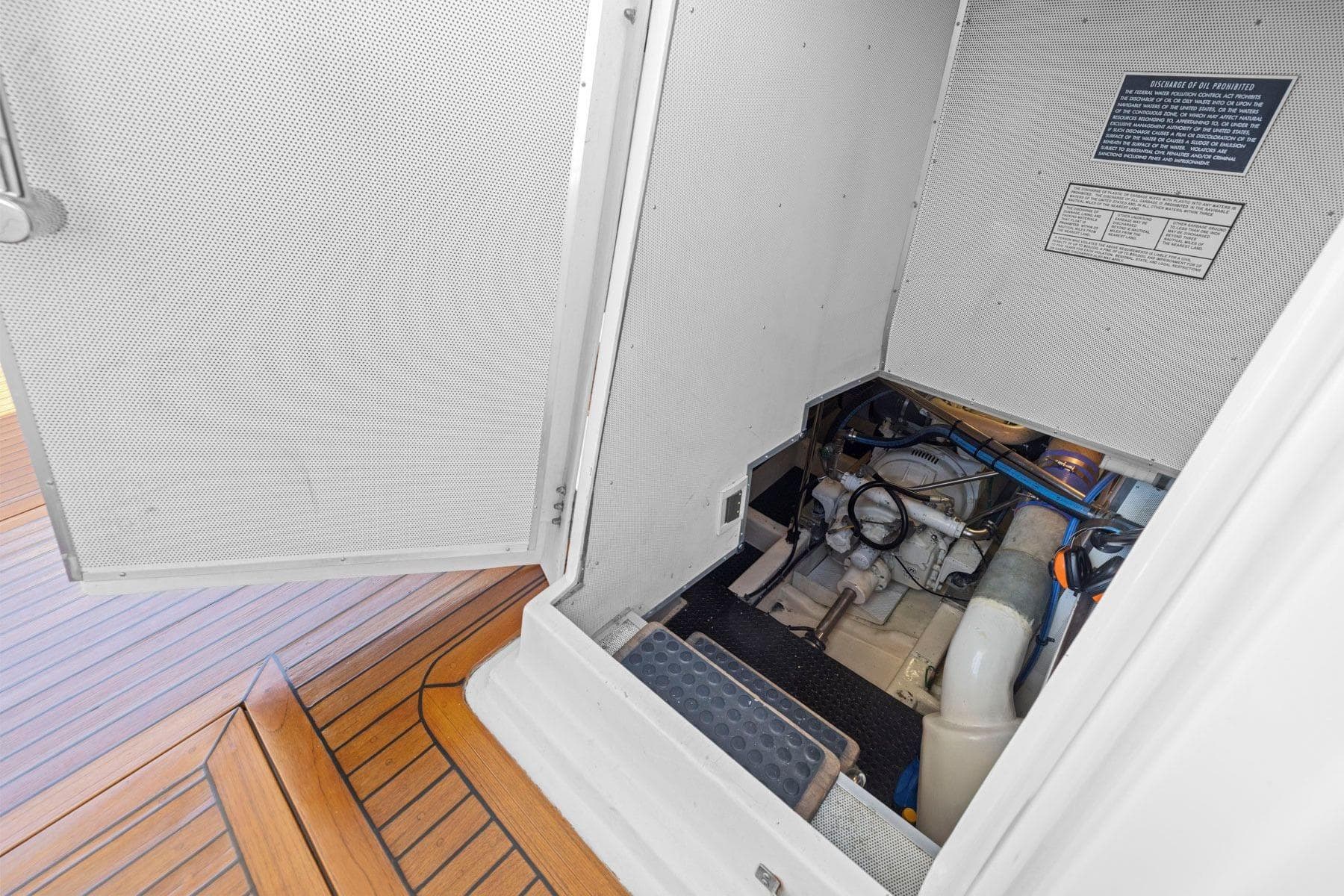 Engine compartment of a 1999 Symbol 55 yacht with wooden deck flooring.