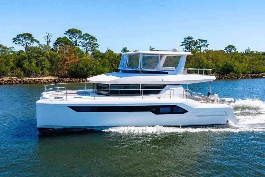 2022 Leopard 53 Powercat cruising on a scenic waterway with lush greenery.