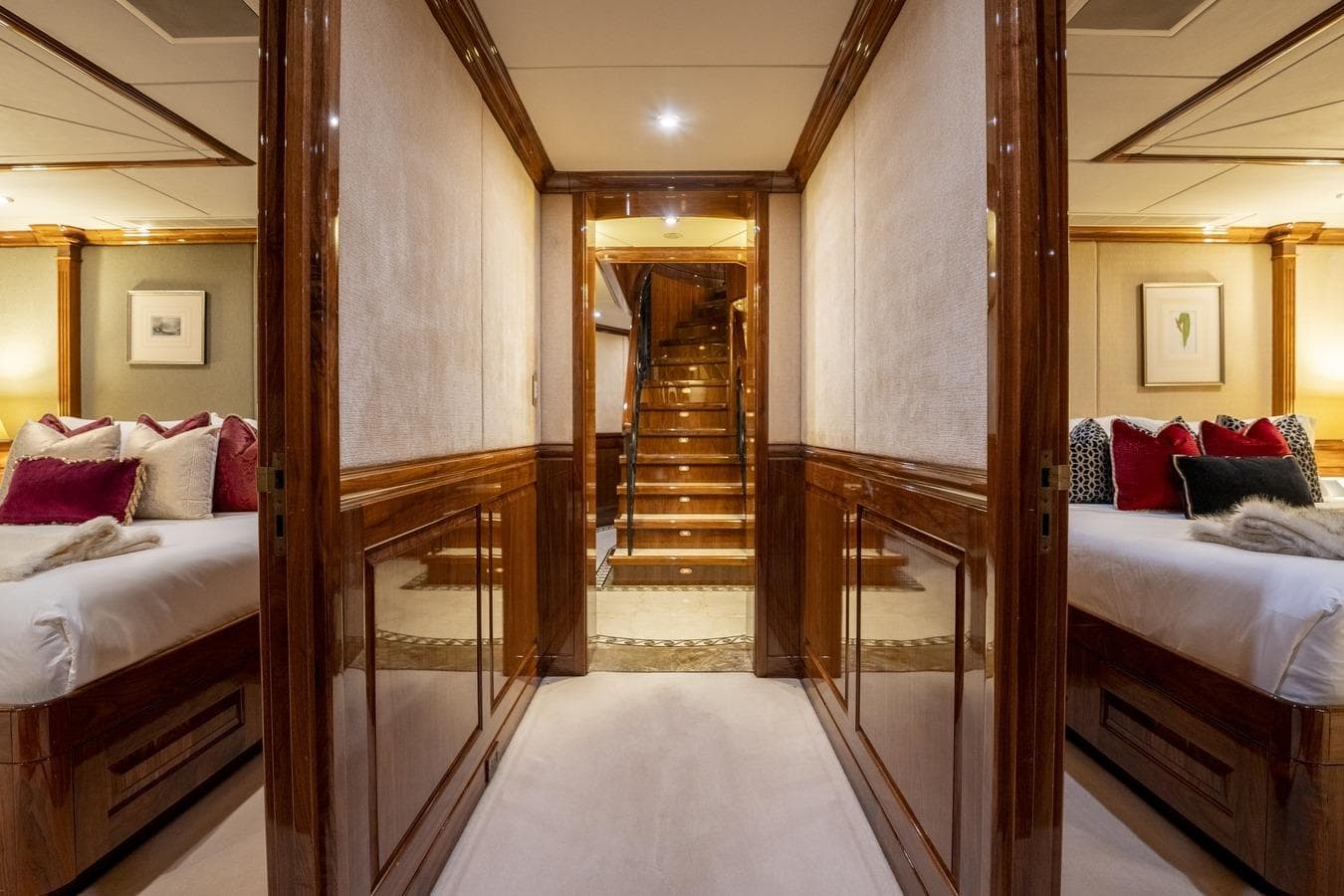 Luxurious interior of 2005 Christensen motor yacht with elegant wood paneling and plush bedding.