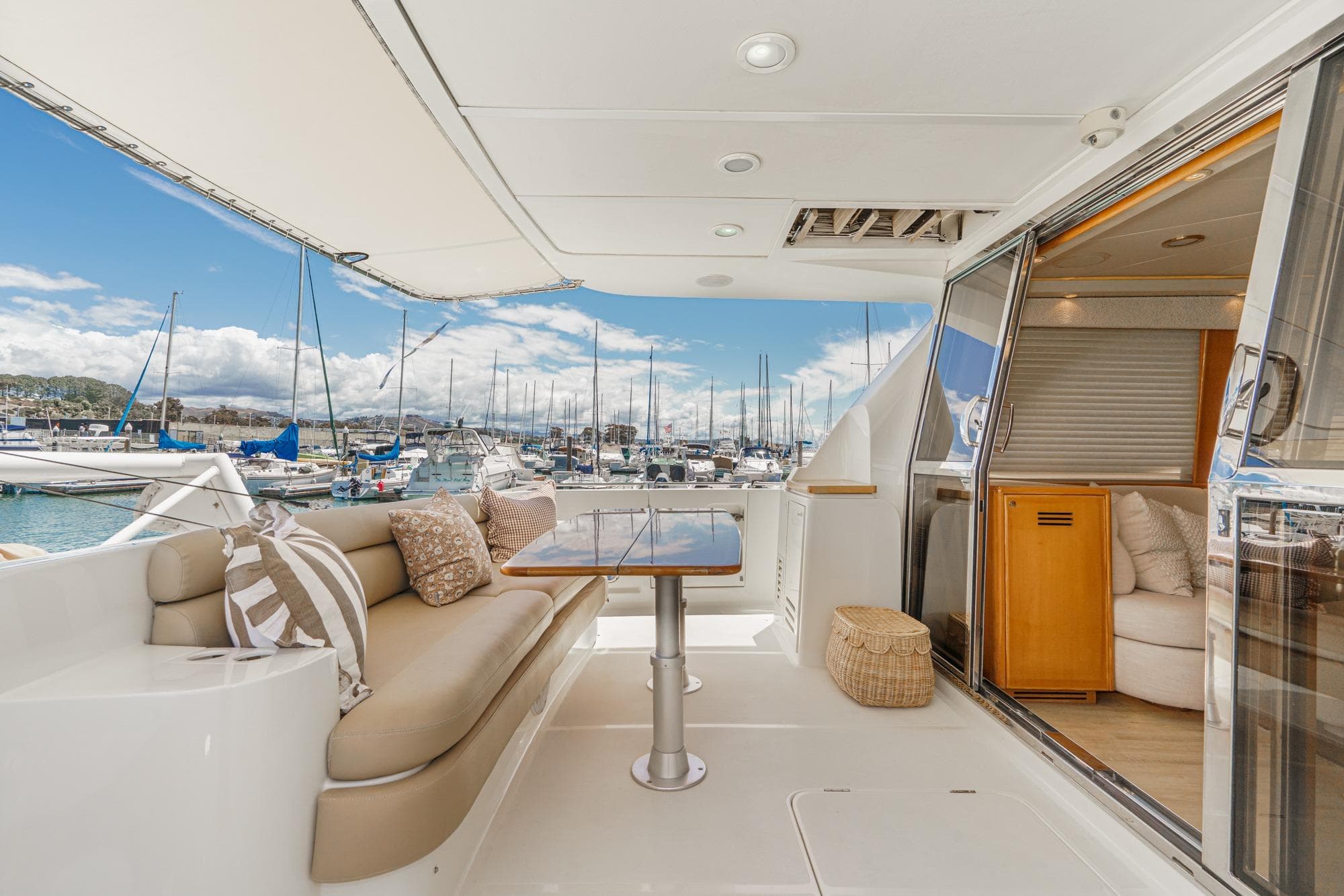 Luxurious 2003 McKinna 65 Pilothouse yacht interior with elegant seating and marina view.
