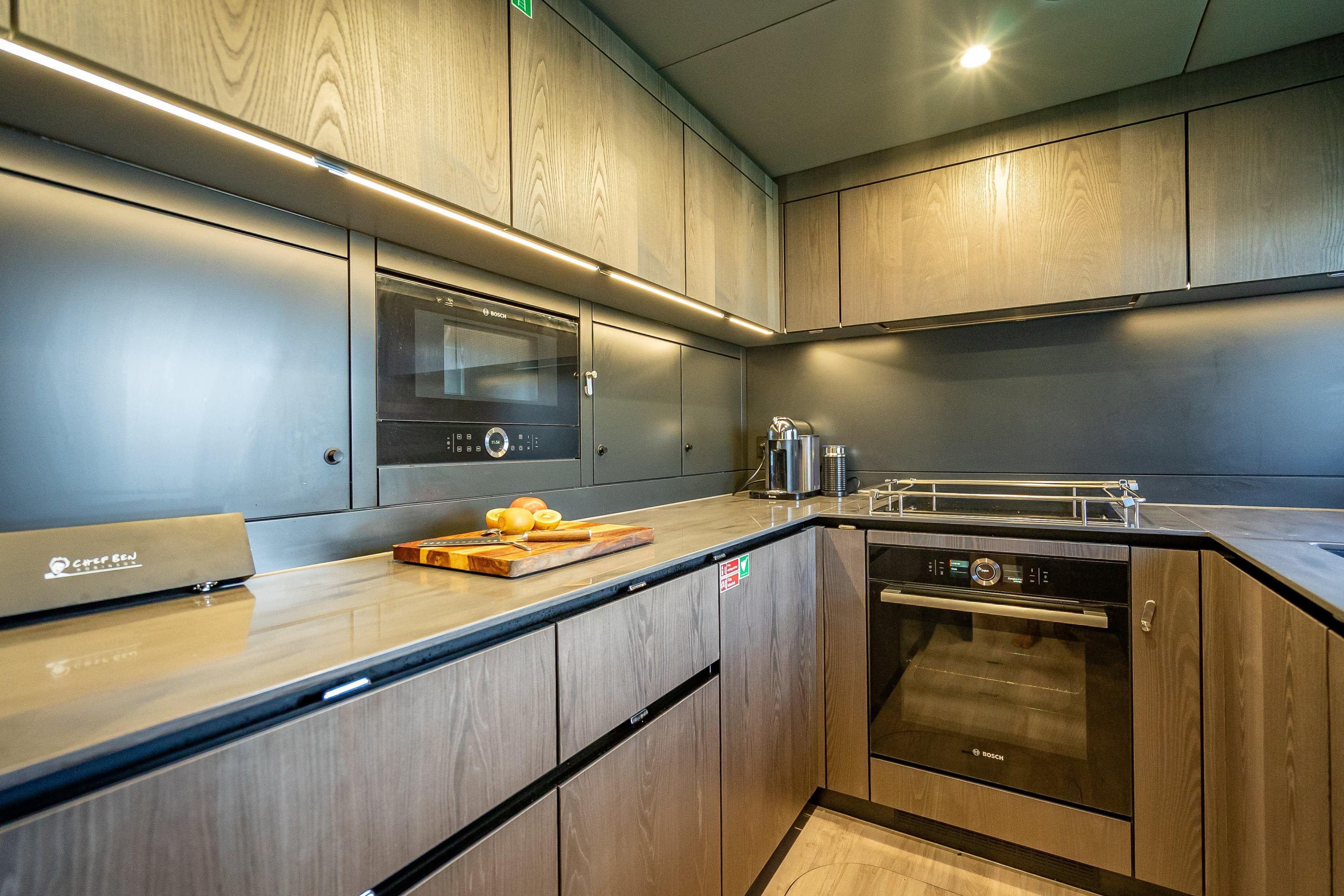 Modern kitchen interior on 2026 Sunreef 60 Power yacht, featuring sleek cabinetry and appliances.