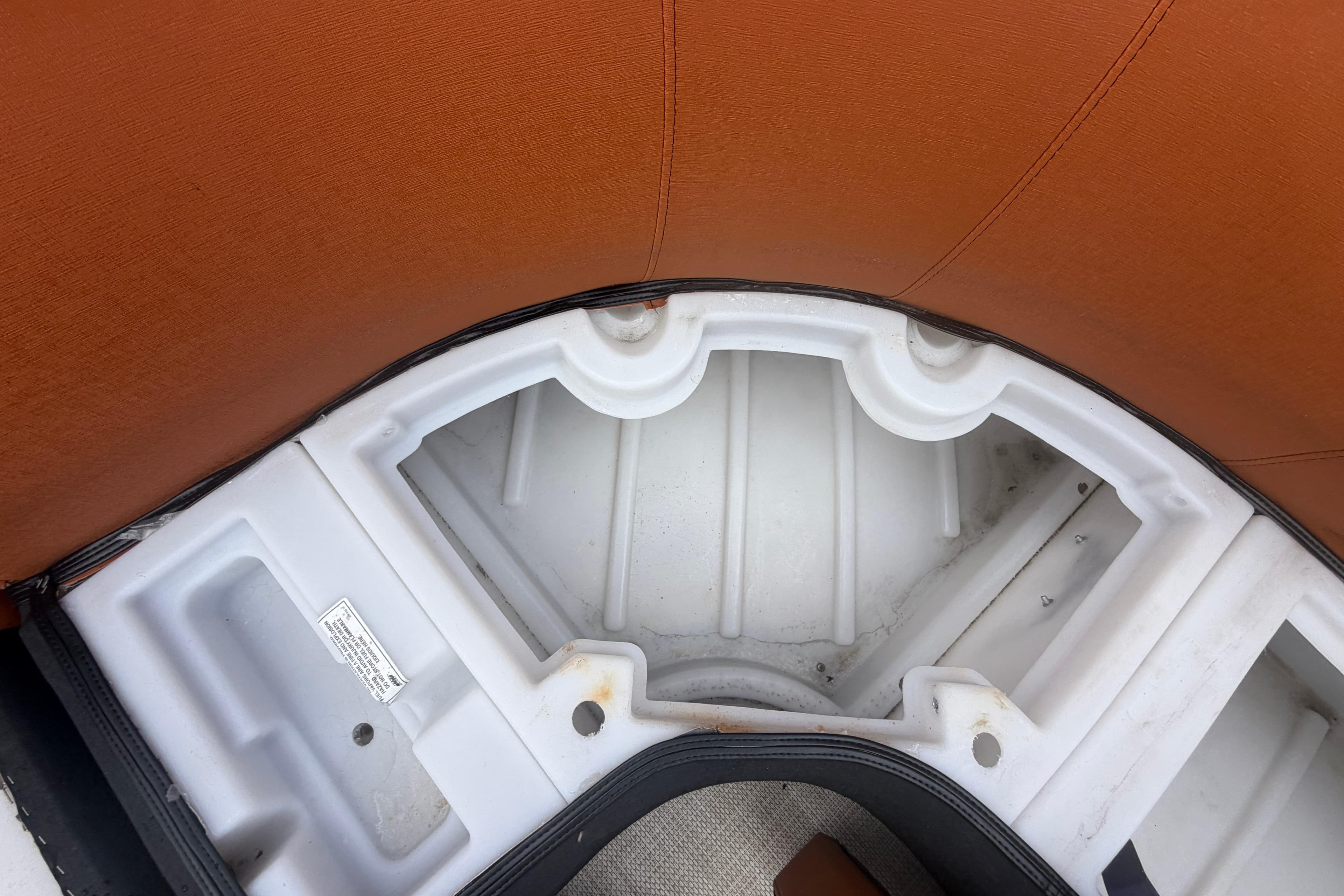 Interior storage compartment of 2015 Premier 290 Grand View boat with brown seating.