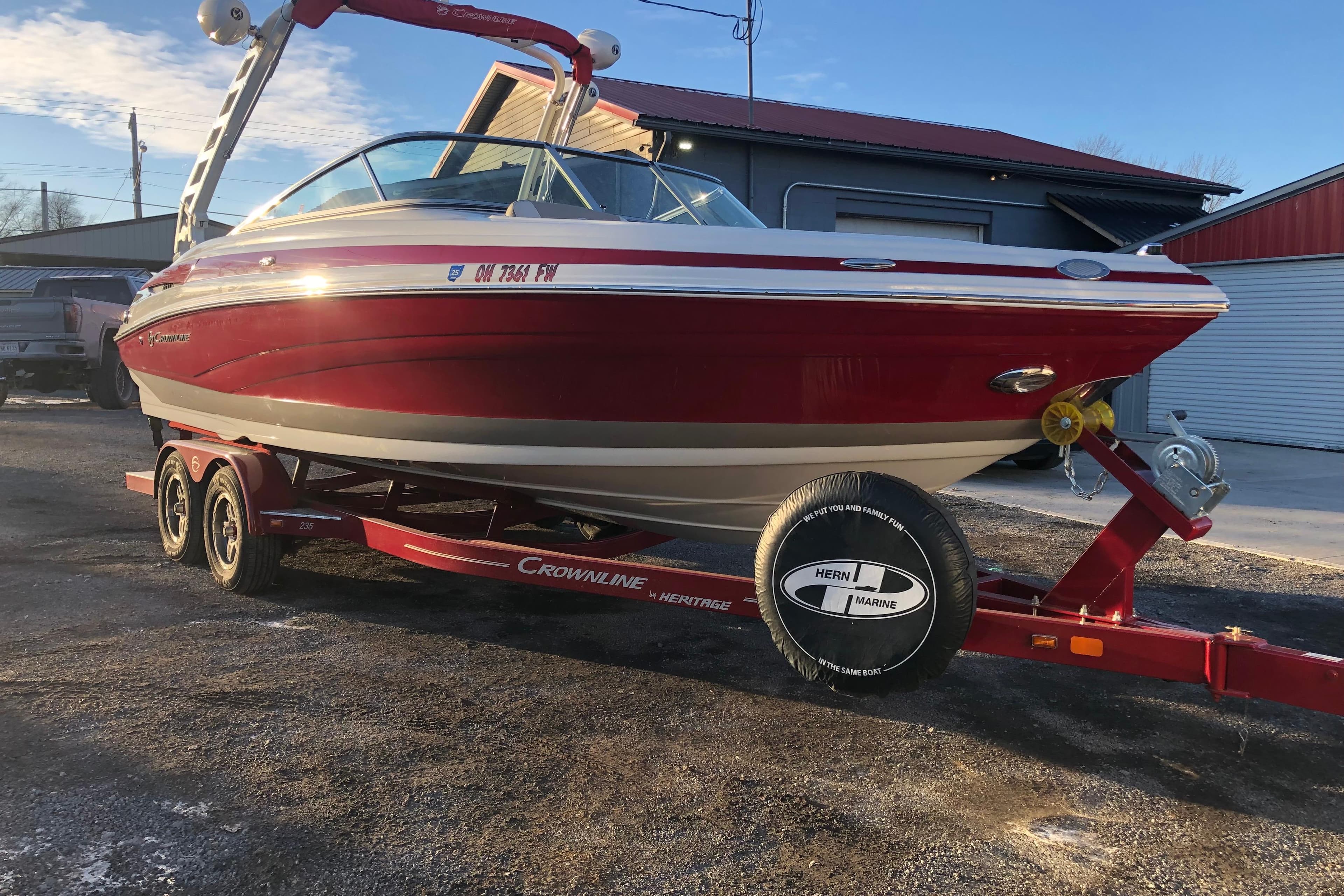 2020 Crownline 235 SS boat on trailer, red and white, parked outdoors.