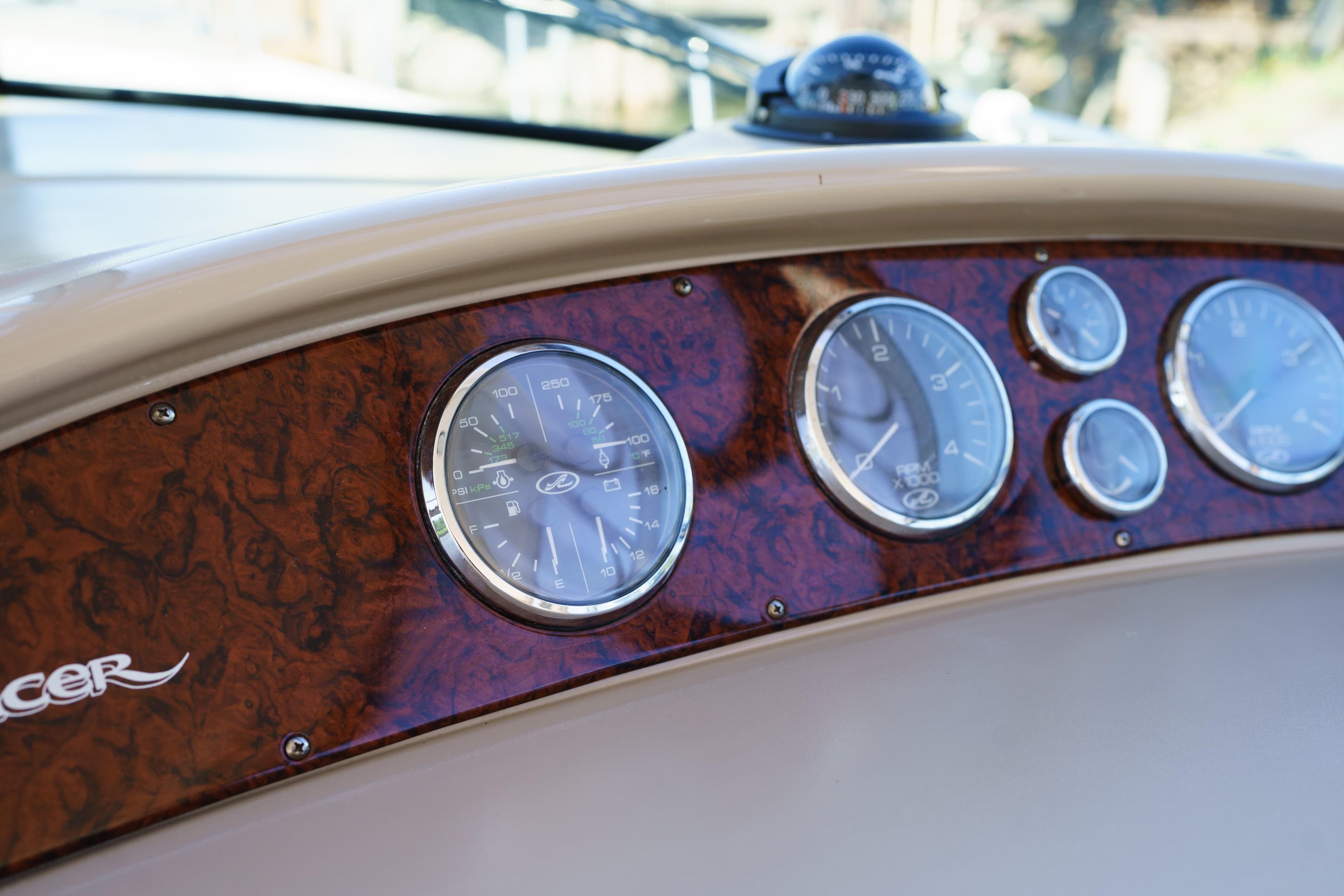 Dashboard of 2004 Sea Ray Sundancer 460 with wood paneling and gauges.