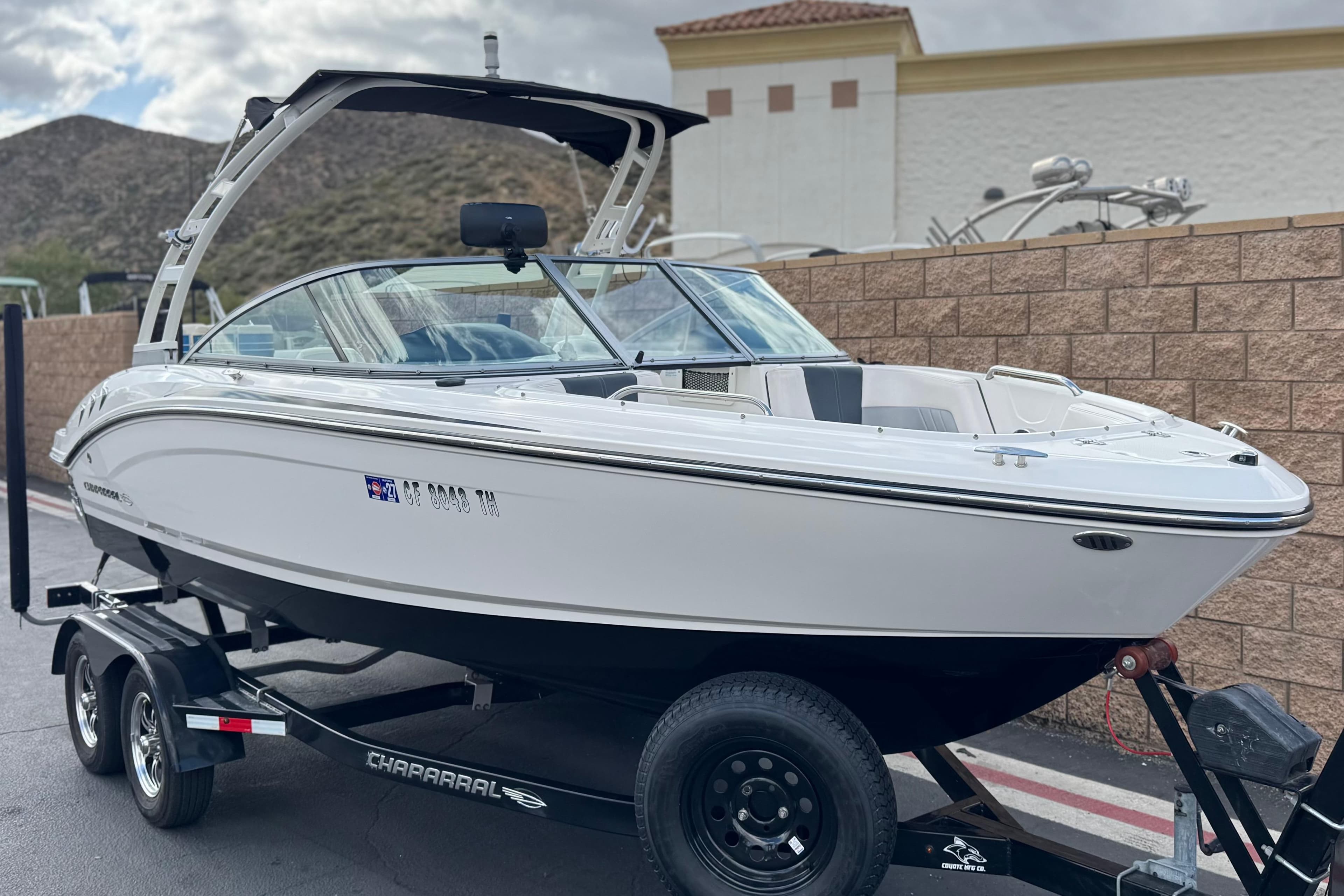 2020 Chaparral 21 Surf boat on trailer, parked outdoors with scenic background.