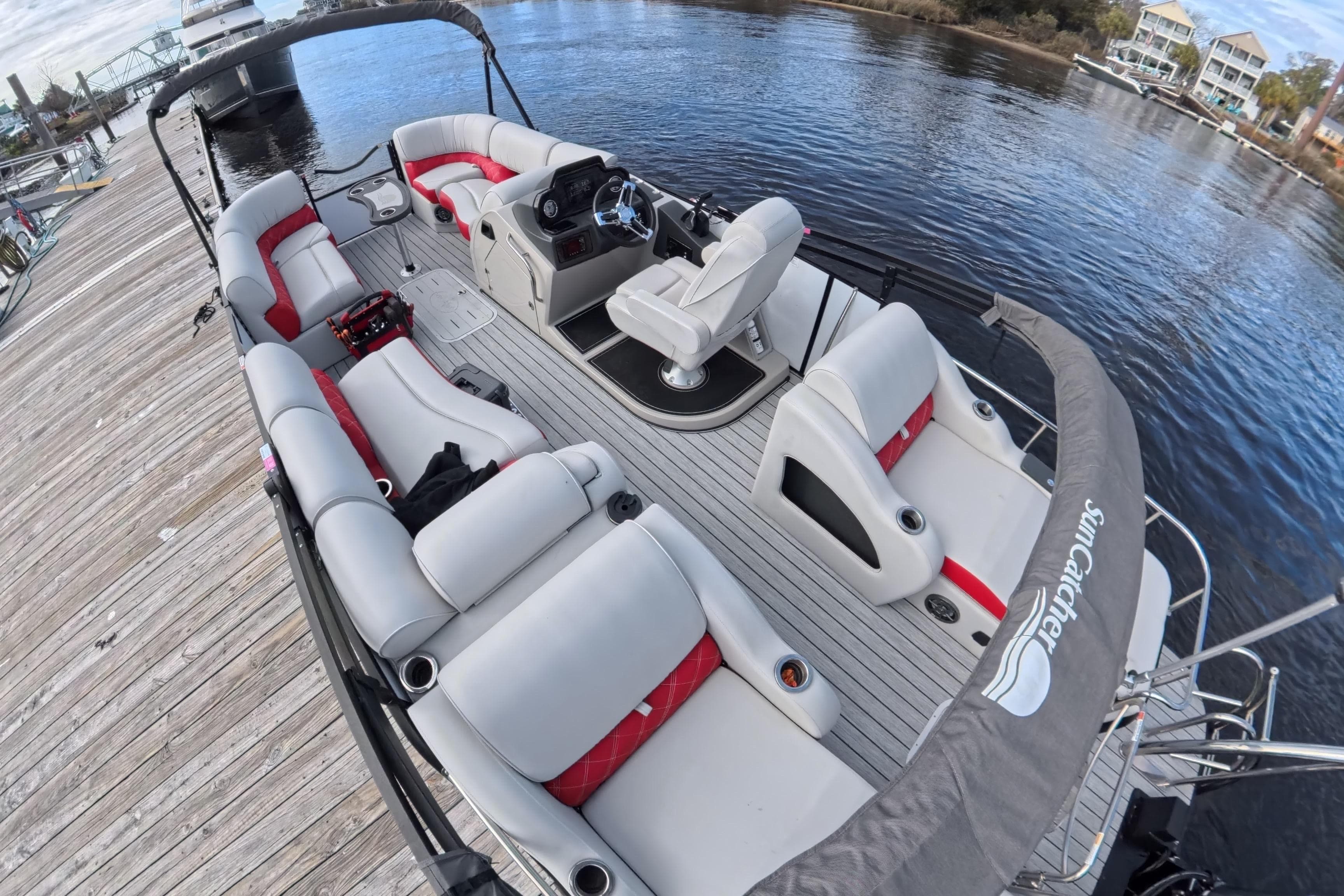 2025 SunCatcher ELITE SERIES 324 SS pontoon boat docked, featuring spacious seating and modern design.