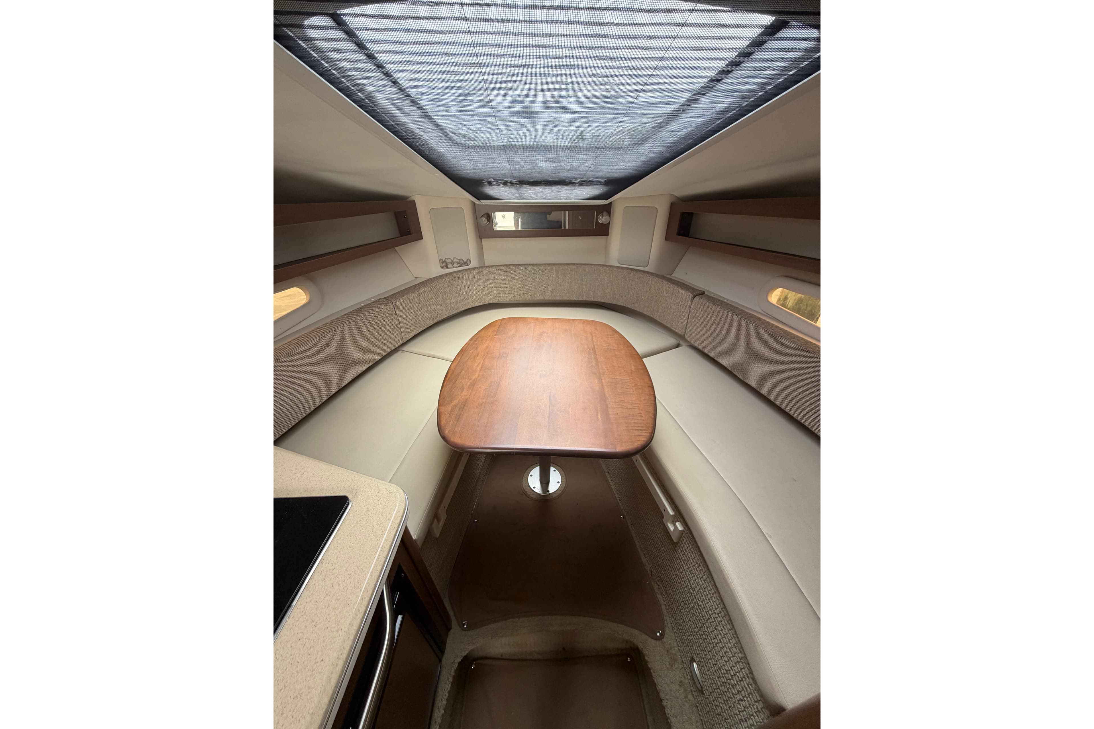 Interior cabin of 2015 Sea Ray 280 Sunrunner with wooden table and seating.