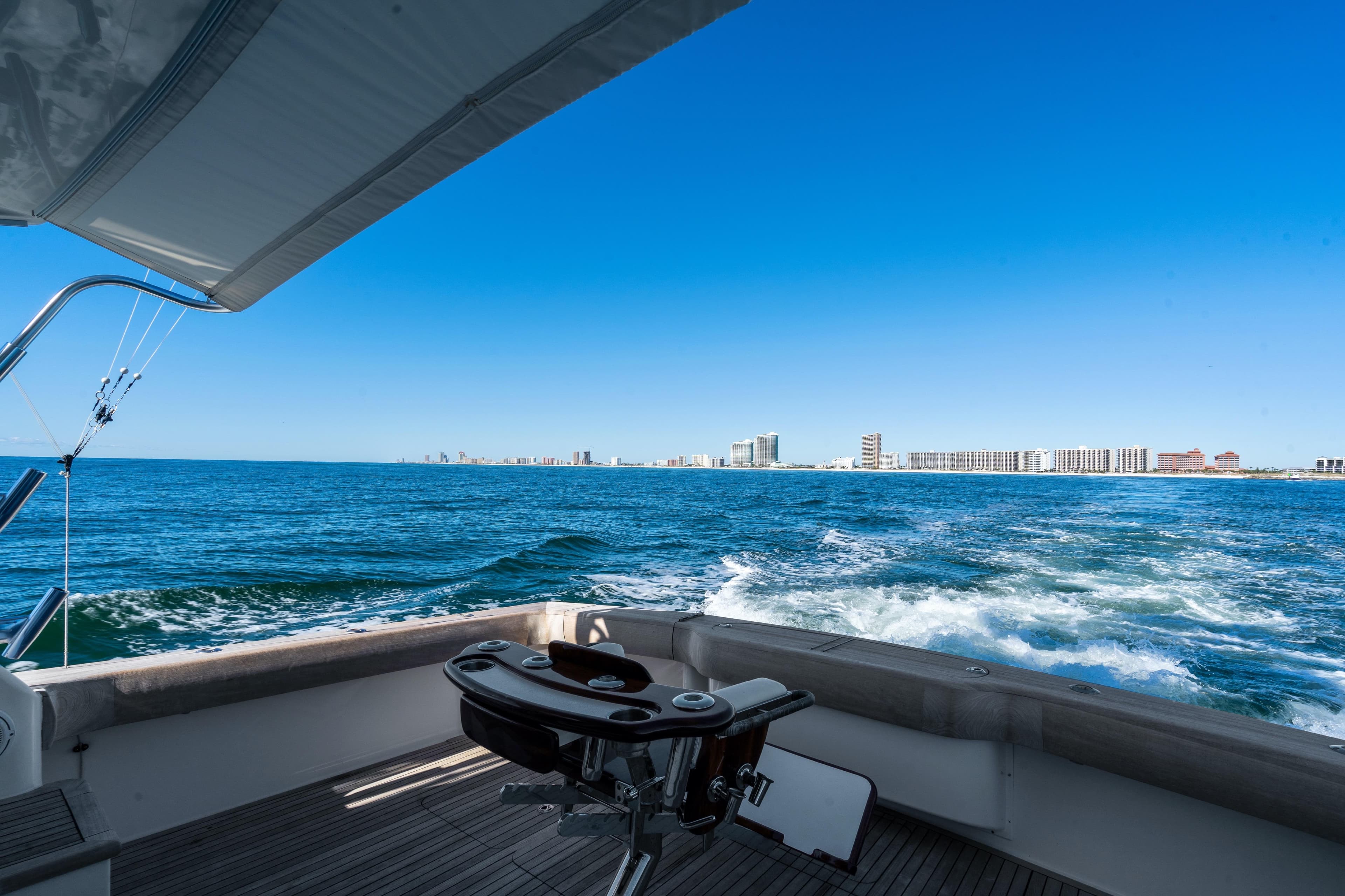 2007 Viking 56 Convertible yacht cruising with city skyline in the background.