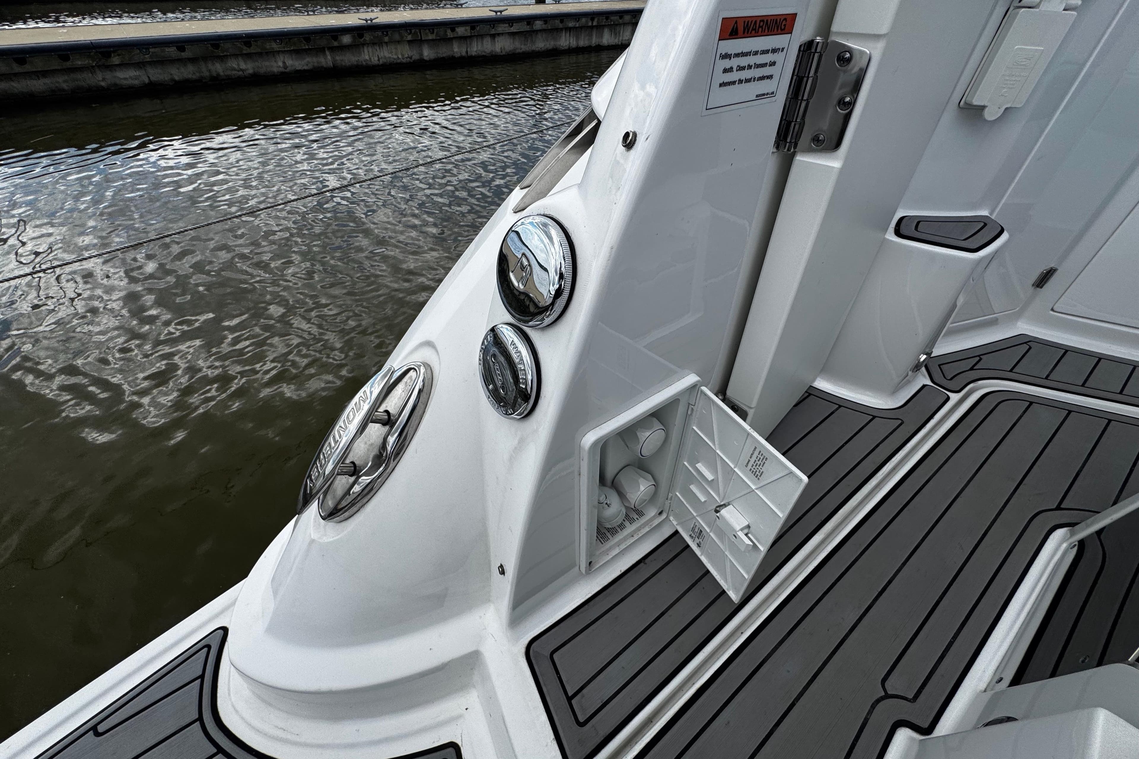 2022 Monterey 295 Sport Yacht deck with storage compartment and sleek design.
